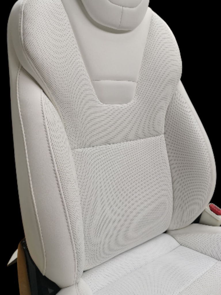 White car seat with perforated leather and headrest against a black backdrop.