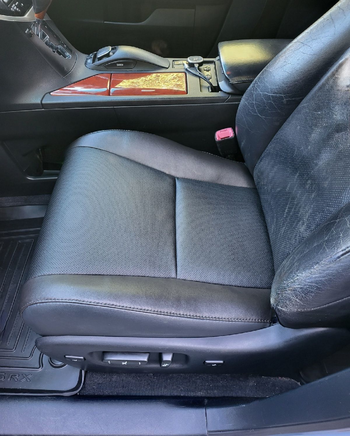 Black leather car seat with power adjustments, adjacent to a center console.
