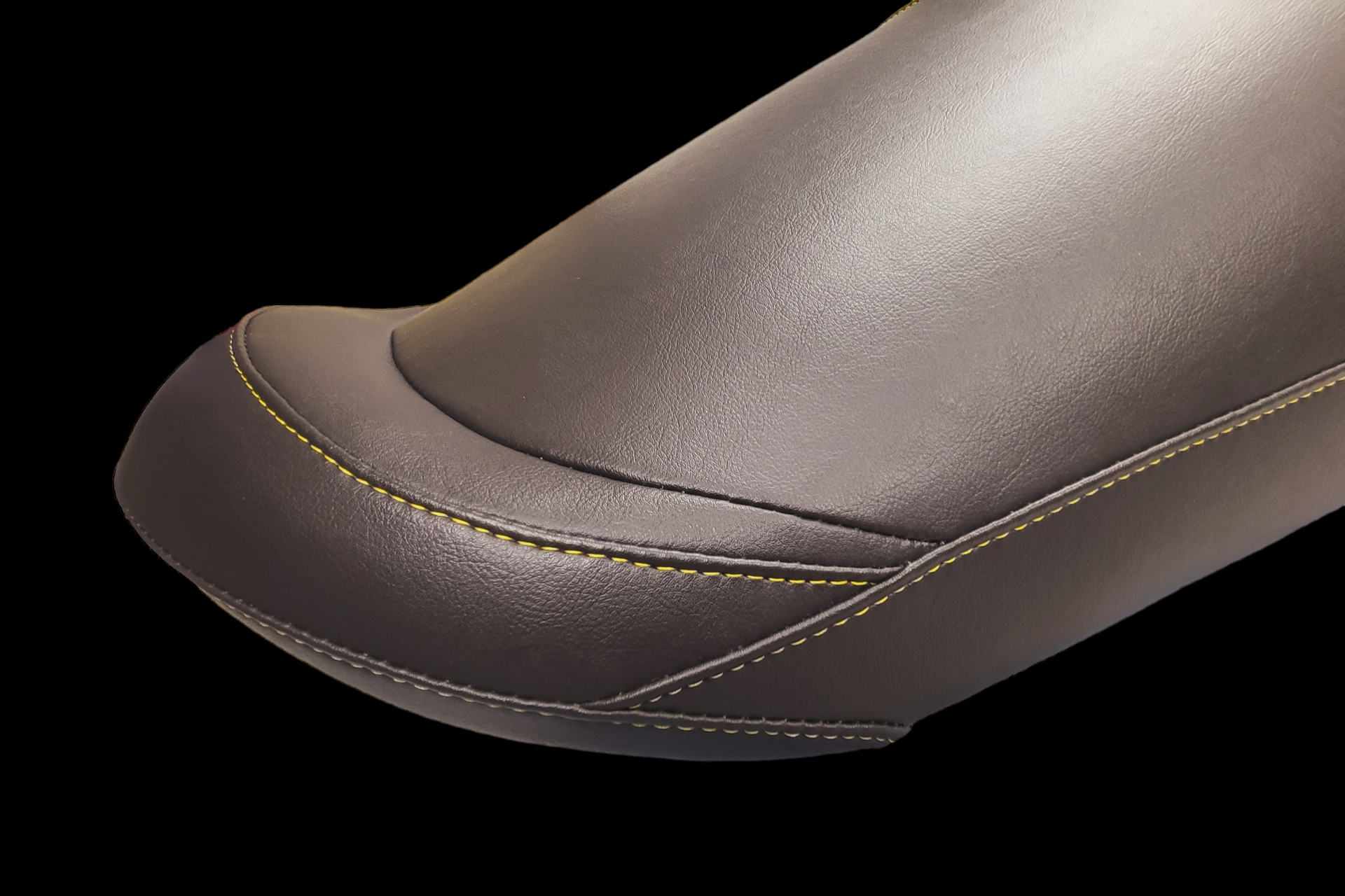 Dark leather seat with yellow stitching.