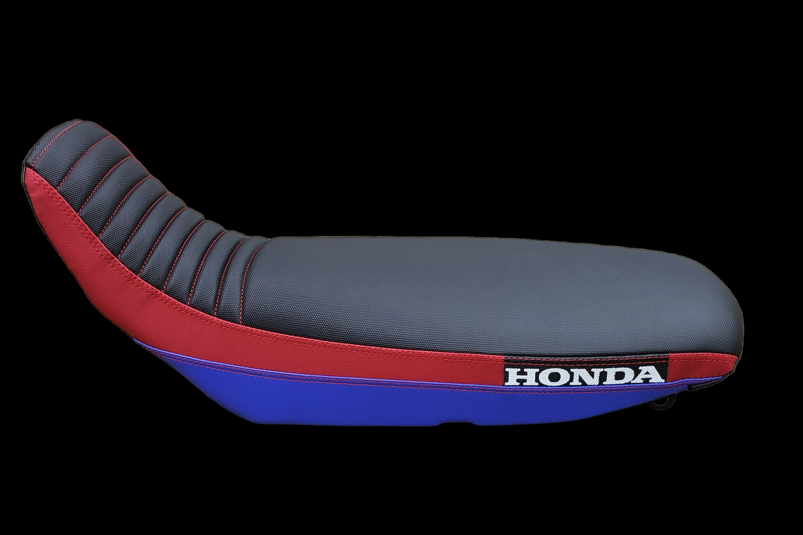 Motorcycle seat with blue, red, and gray sections, and HONDA logo.