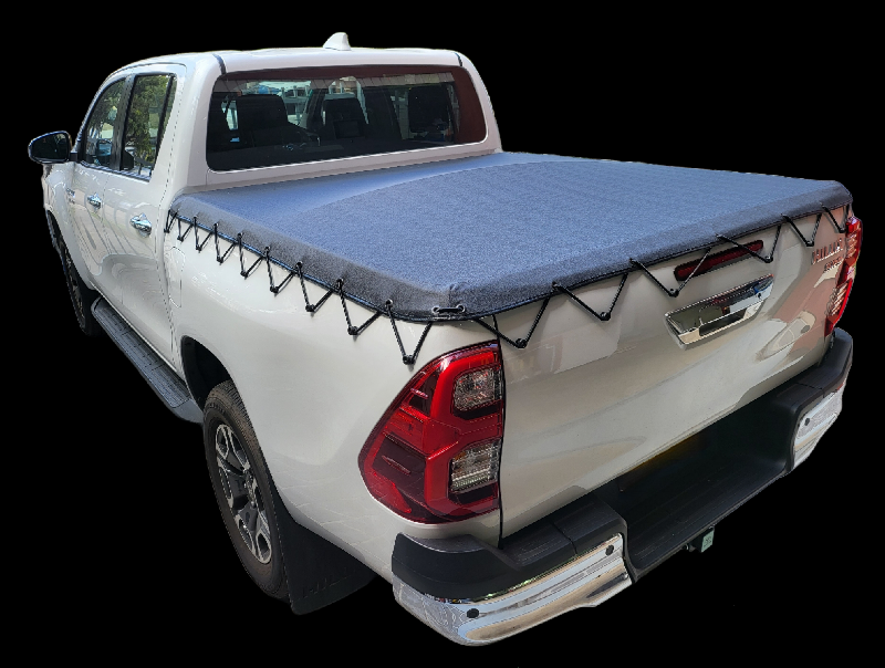 White pickup truck with a blue bed cover, black accents, and a black background.
