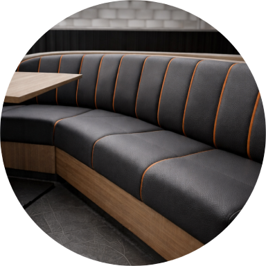 Close-up of a black chair seat with a textured surface and rounded edges.