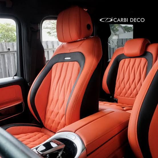 Black leather car interior with a front seat, steering wheel, and console.