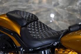 Black quilted motorcycle seat on a gold motorcycle.