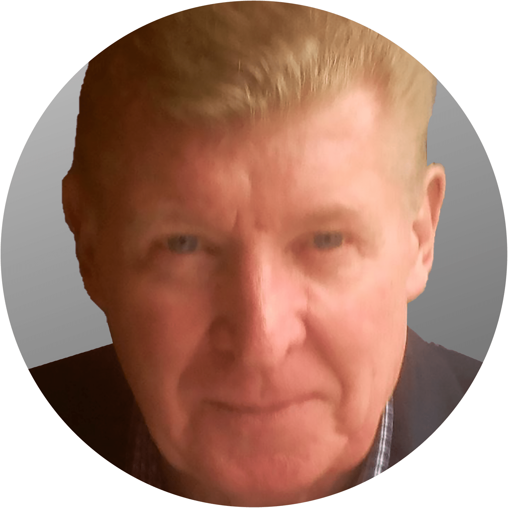 Man with blond hair, wearing a dark jacket, looking at the camera.