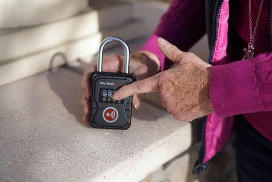 A person is holding a padlock in their hand and pointing at it.