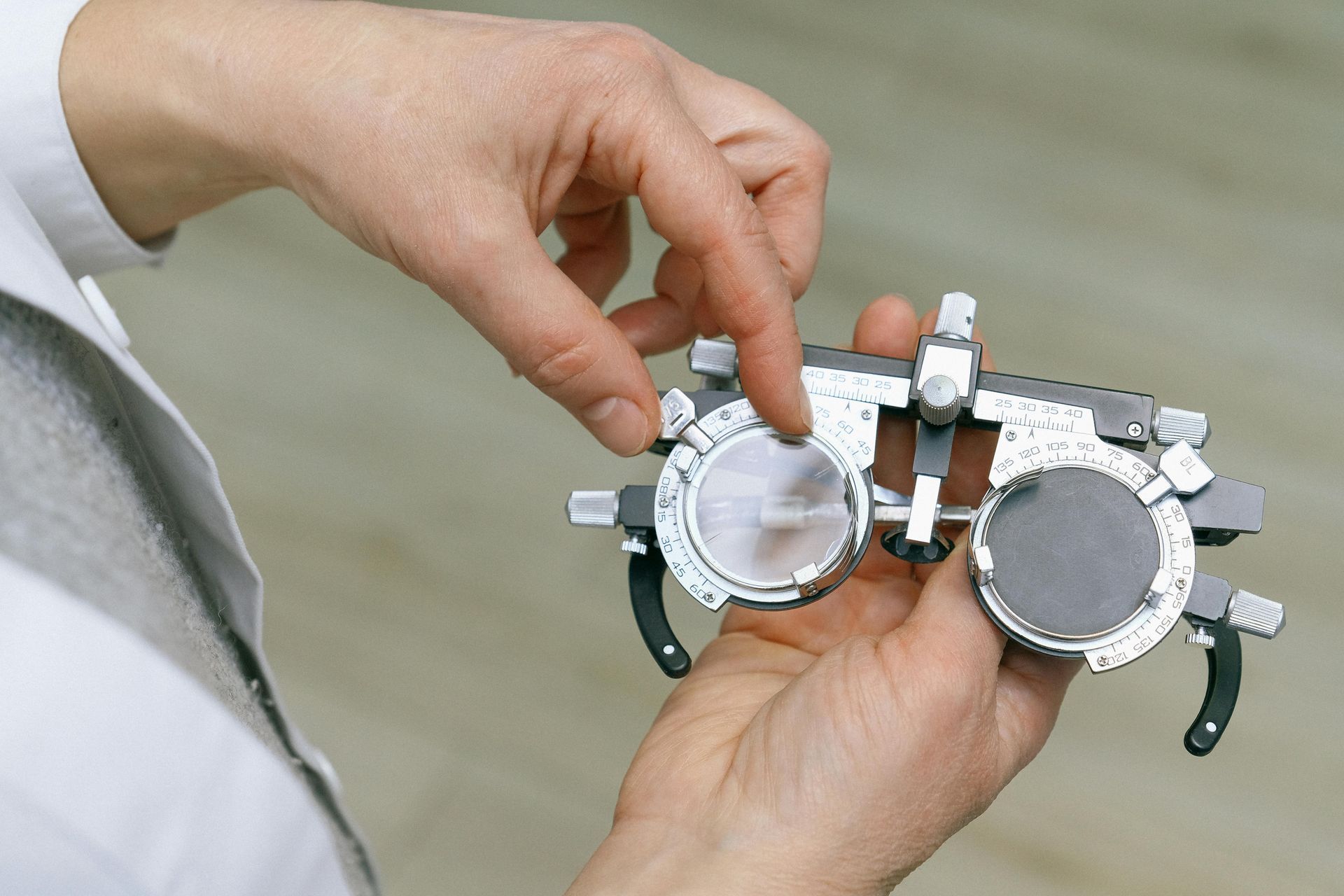 A person is holding a pair of glasses in their hands - vision test