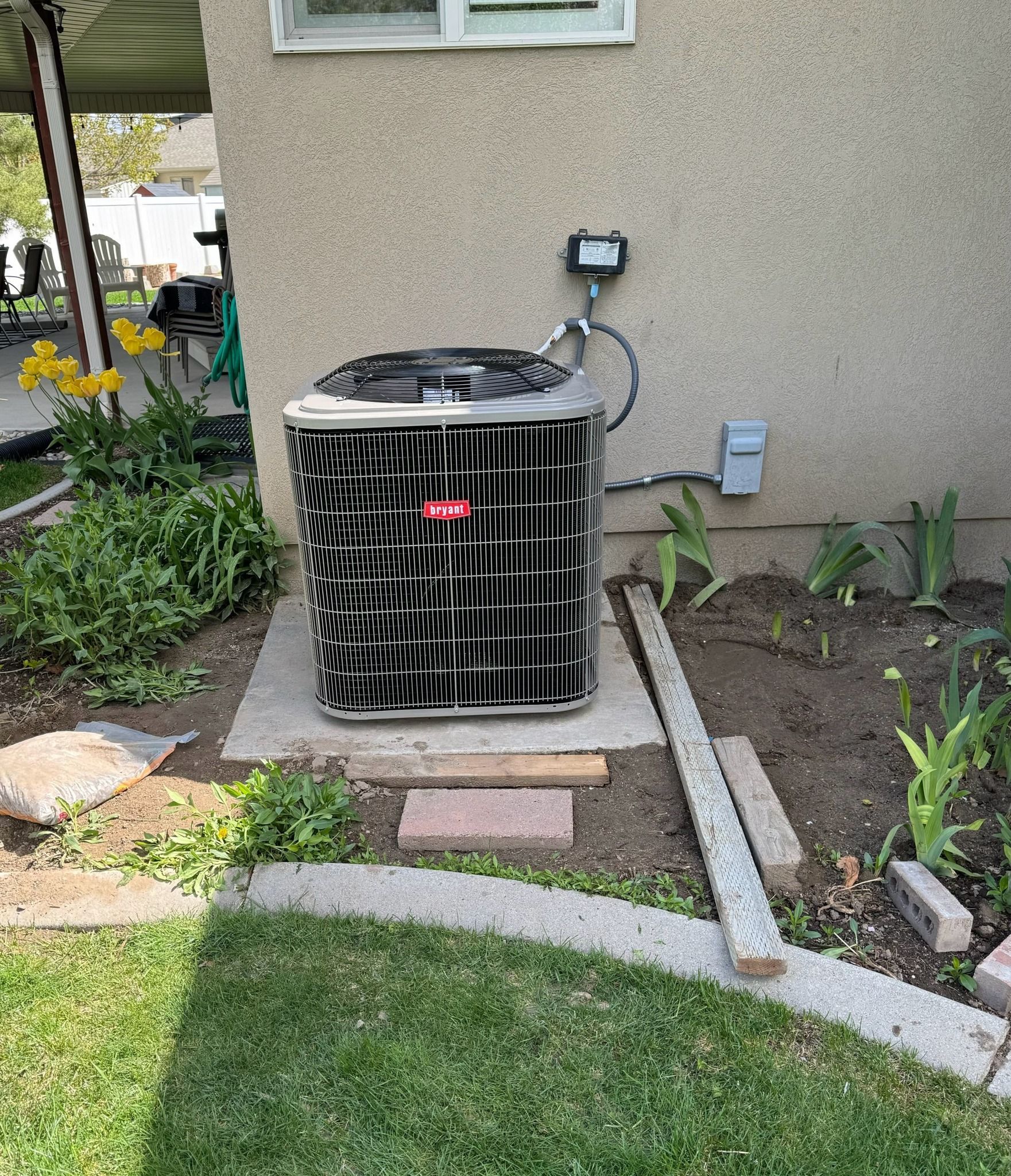 An air conditioner is sitting on the side of a house.