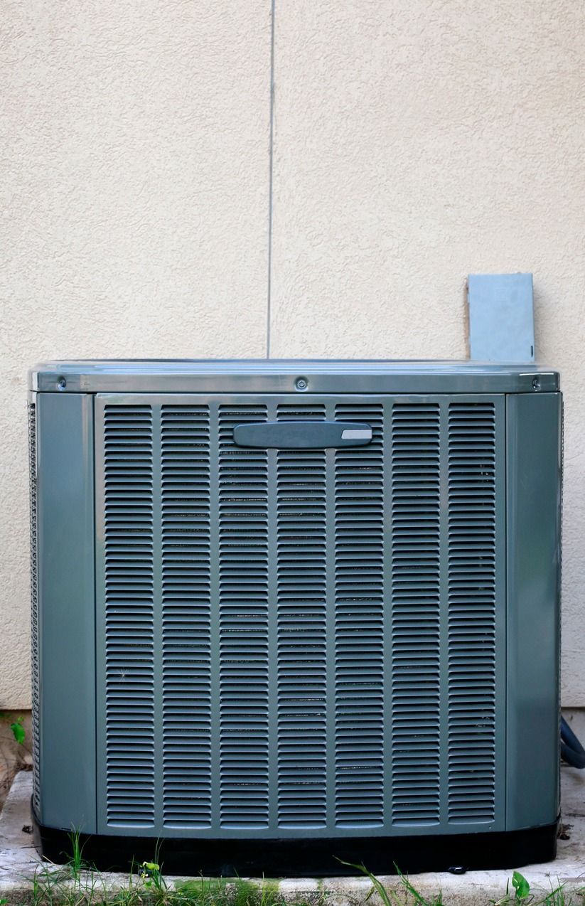 A large air conditioner is sitting on the side of a building.