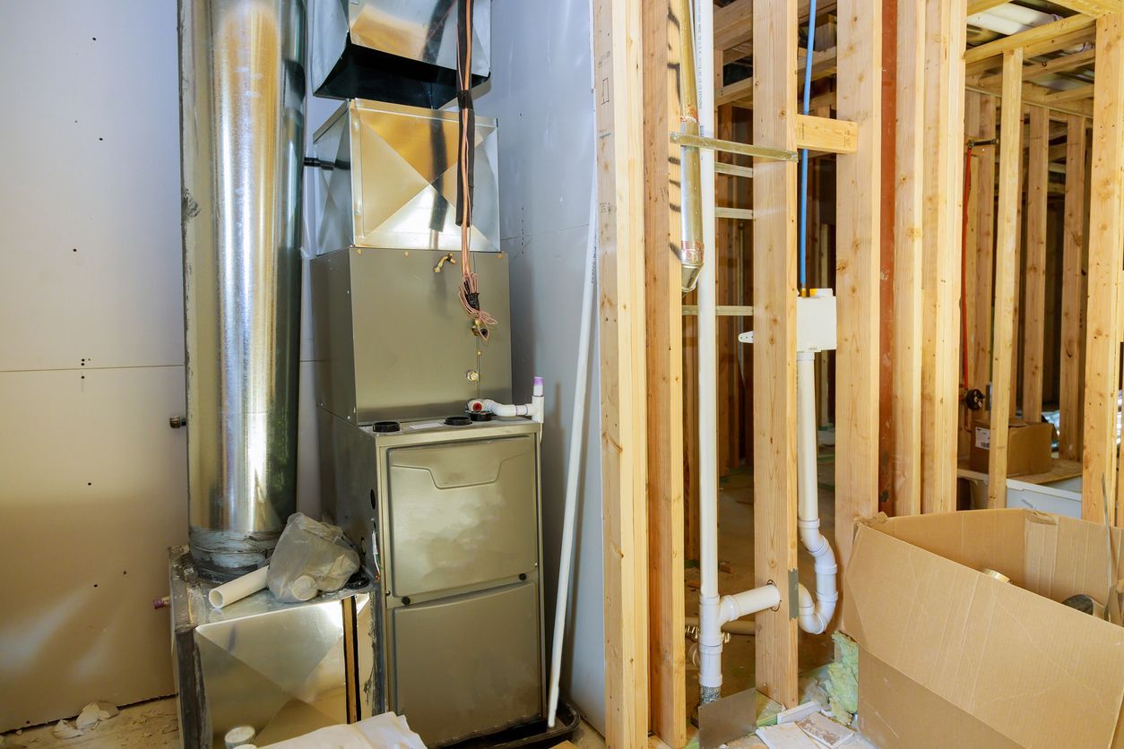 A furnace is sitting in a room in a house under construction.