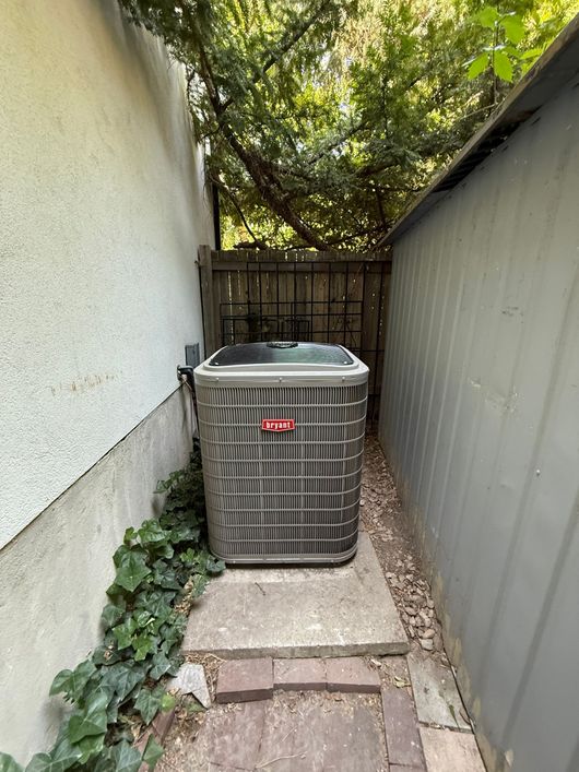 A large air conditioner is sitting on the side of a building.