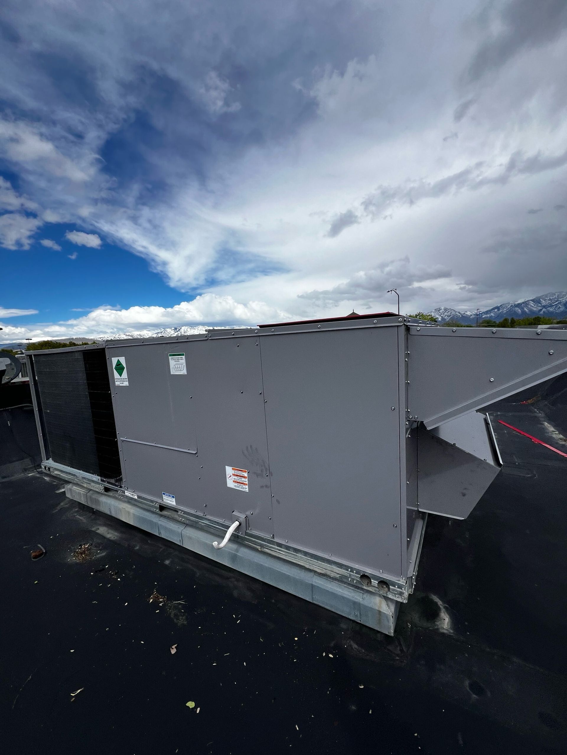 A large gray box is sitting on top of a black roof.