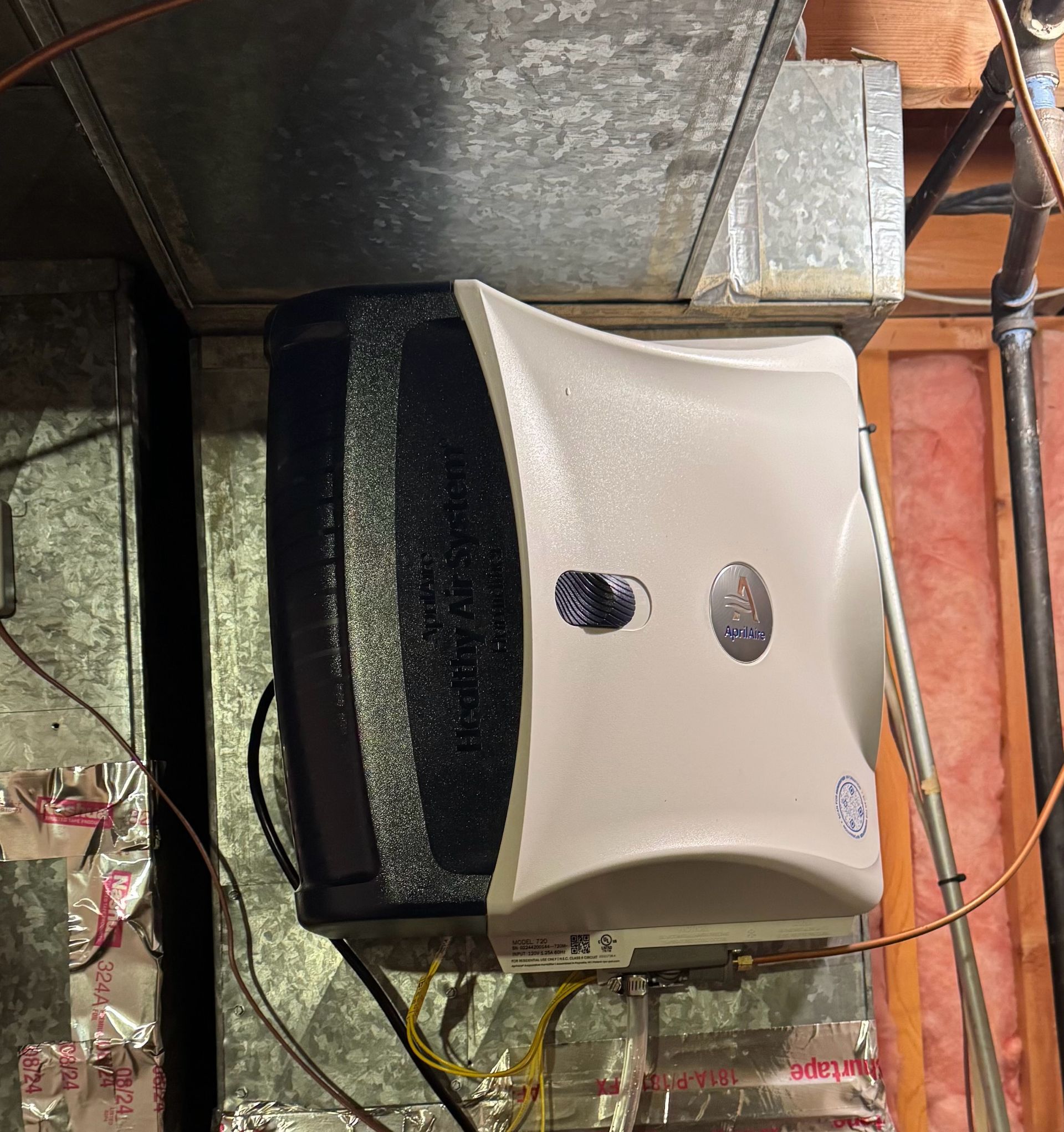 A white appliance is hanging from the ceiling in a room.