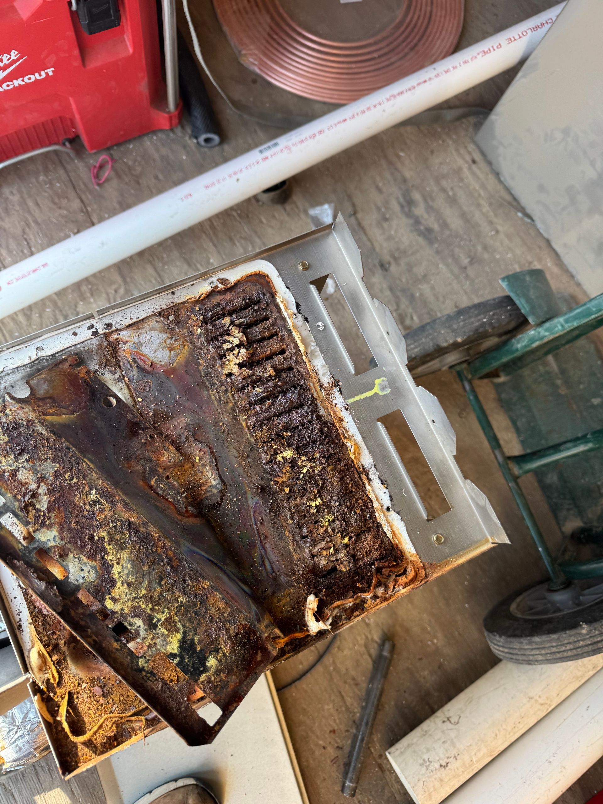 A piece of rusty metal is sitting on a table next to a vacuum cleaner.