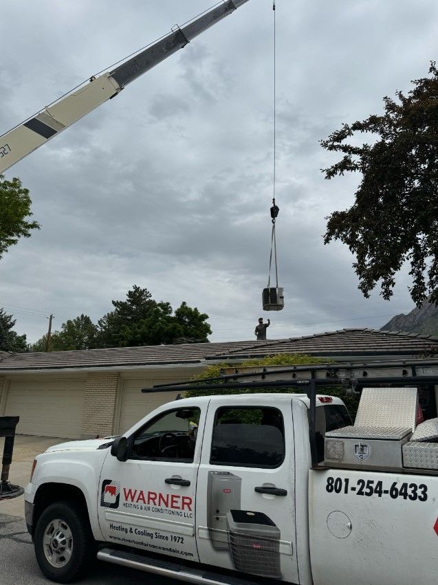 A white warner truck is parked in front of a house.