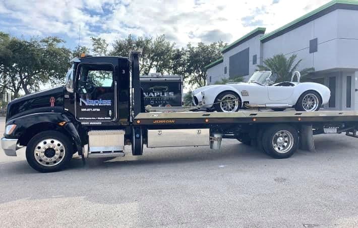 Black Truck Towing a White Car | Naples Towing & Recovery
