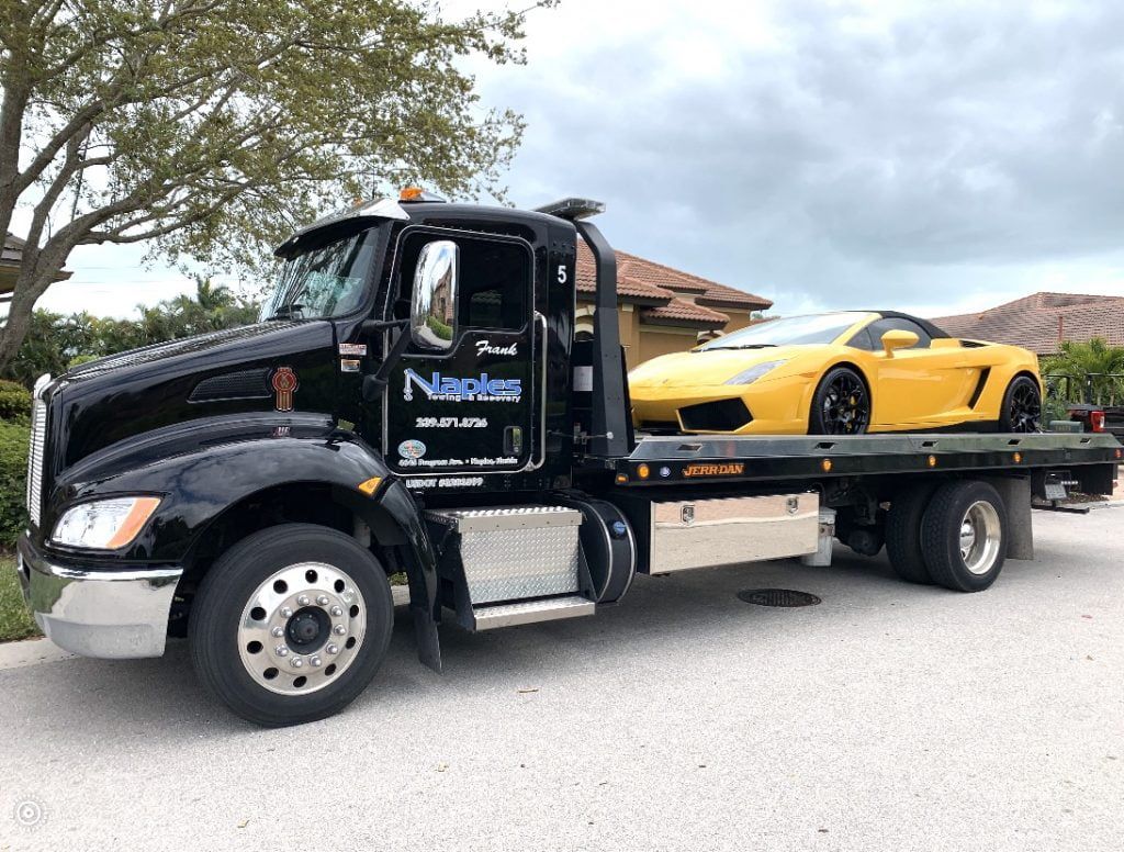 Black Truck Towing a White Car | Naples Towing & Recovery