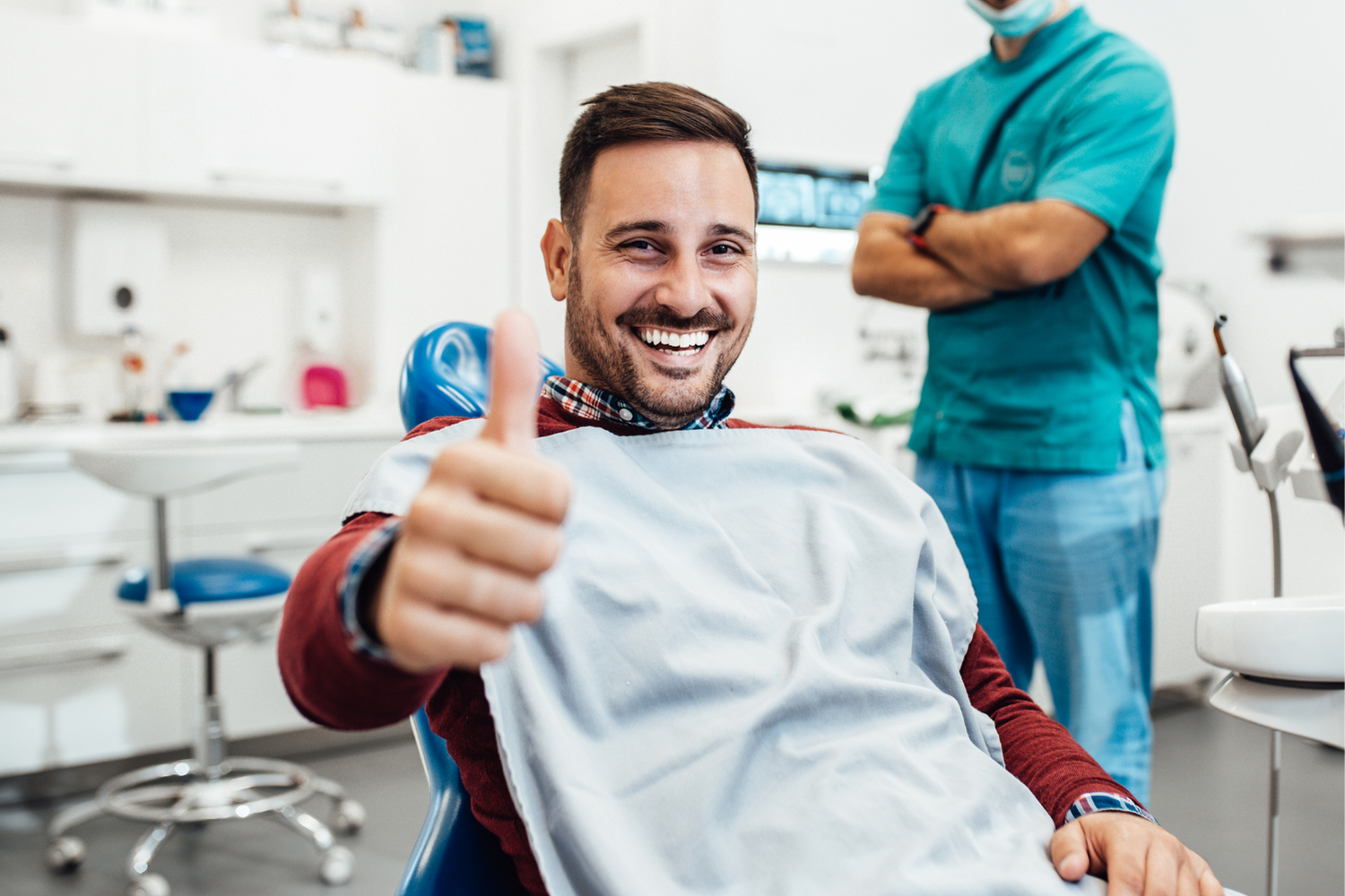 Dentist pointing at teeth on a screen during a consultation in an office.