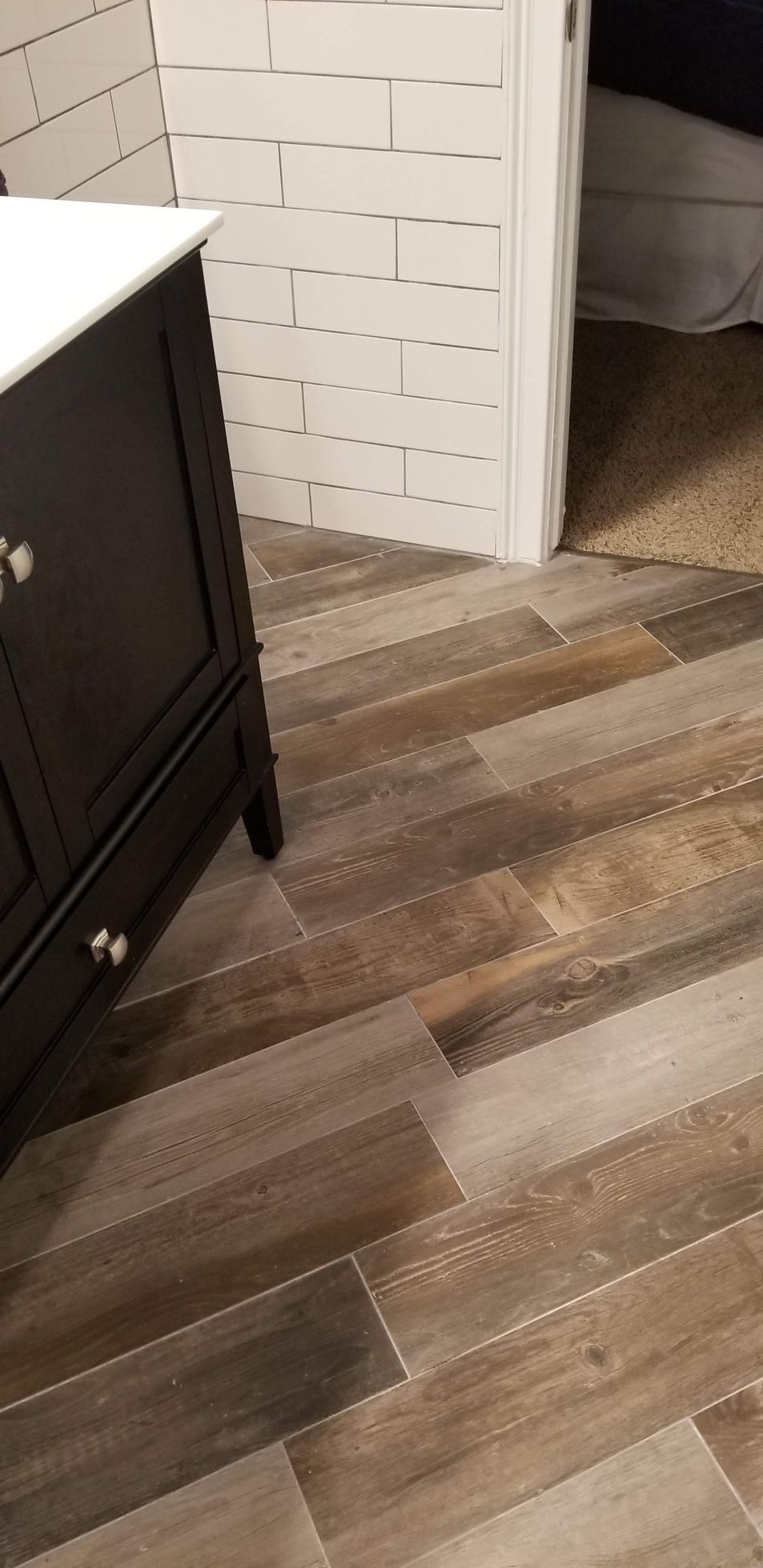 A bathroom with a wooden floor and a black vanity.