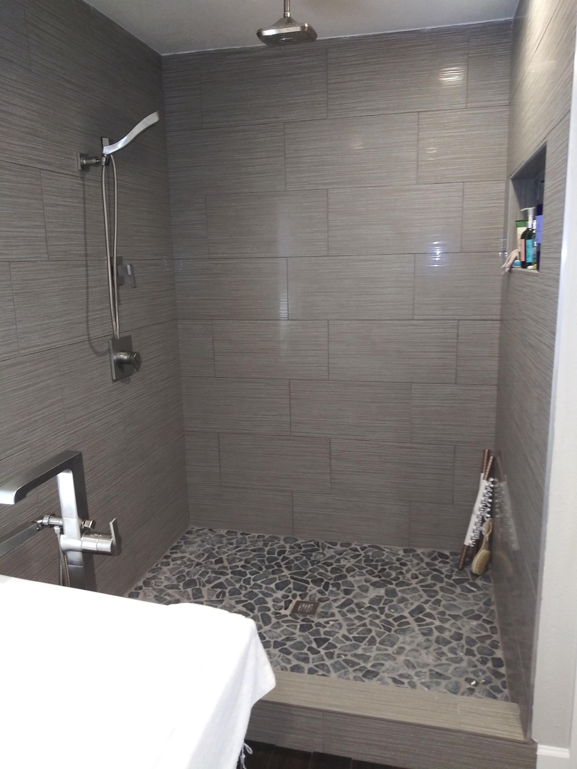 A bathroom with a walk in shower and a sink.