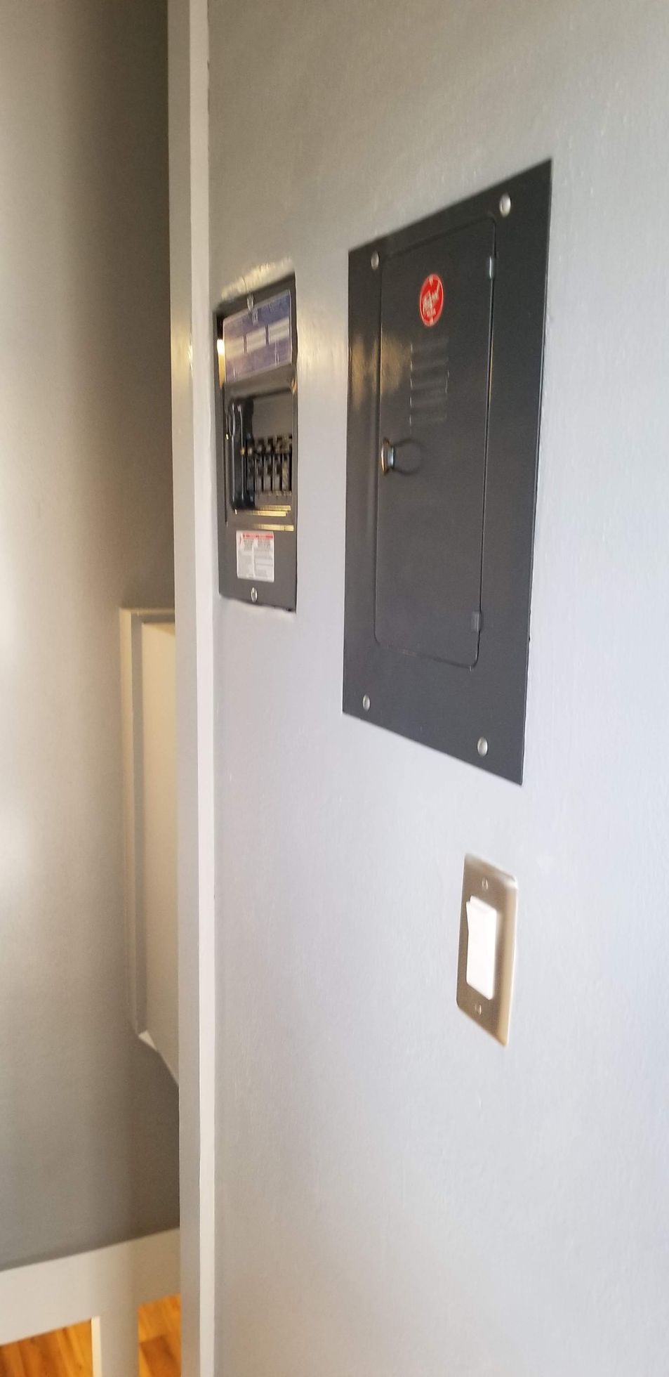 There is a electrical box on the wall next to the stairs.