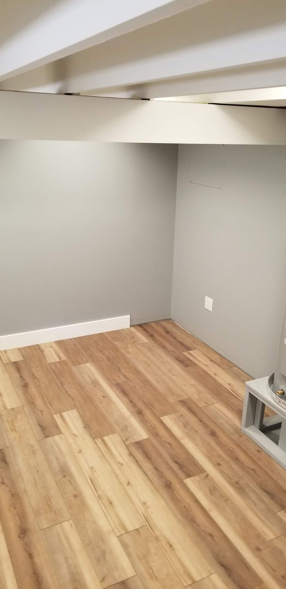 A room with a wooden floor and gray walls.