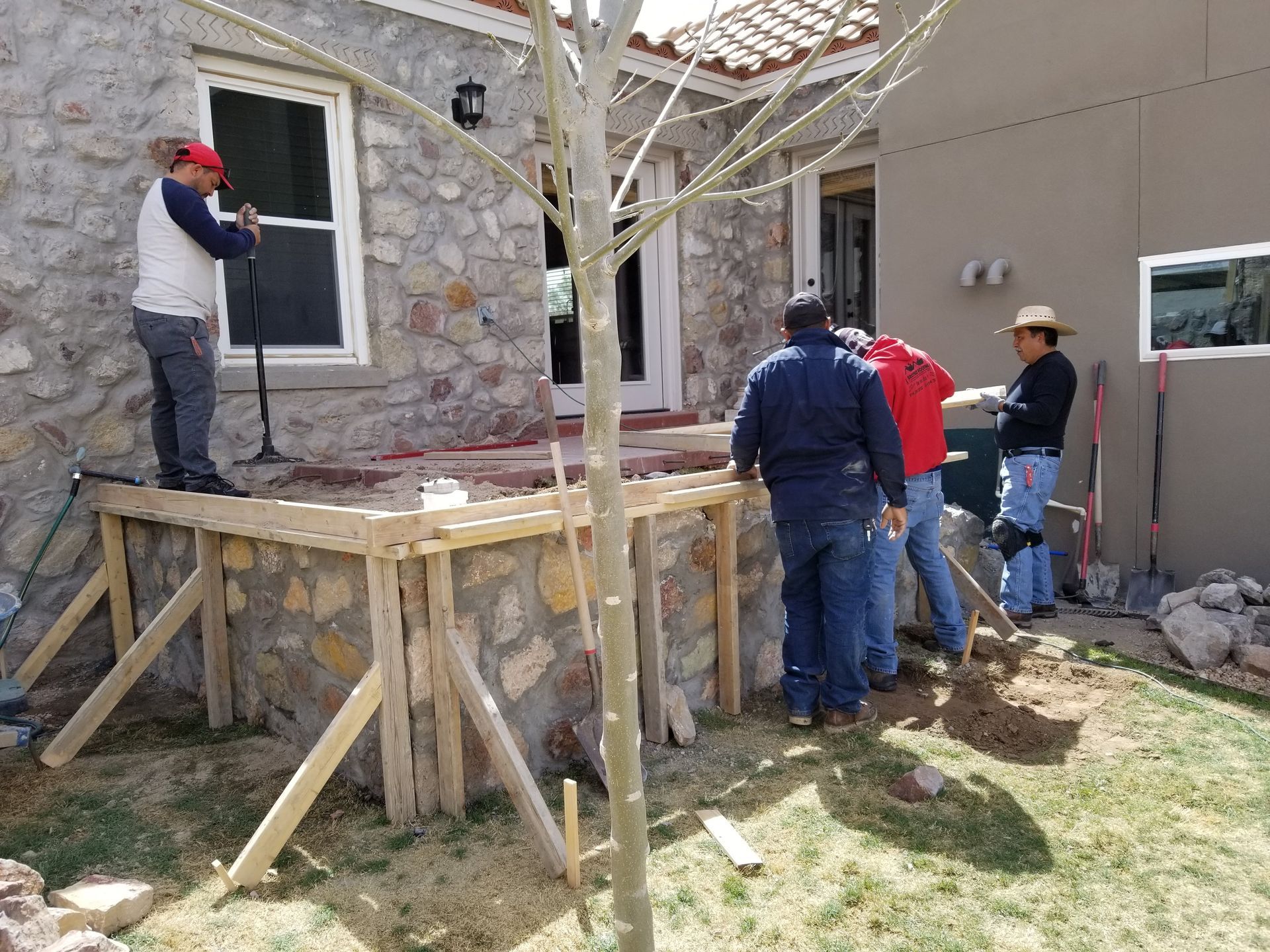 A group of construction workers are working on a stone wall