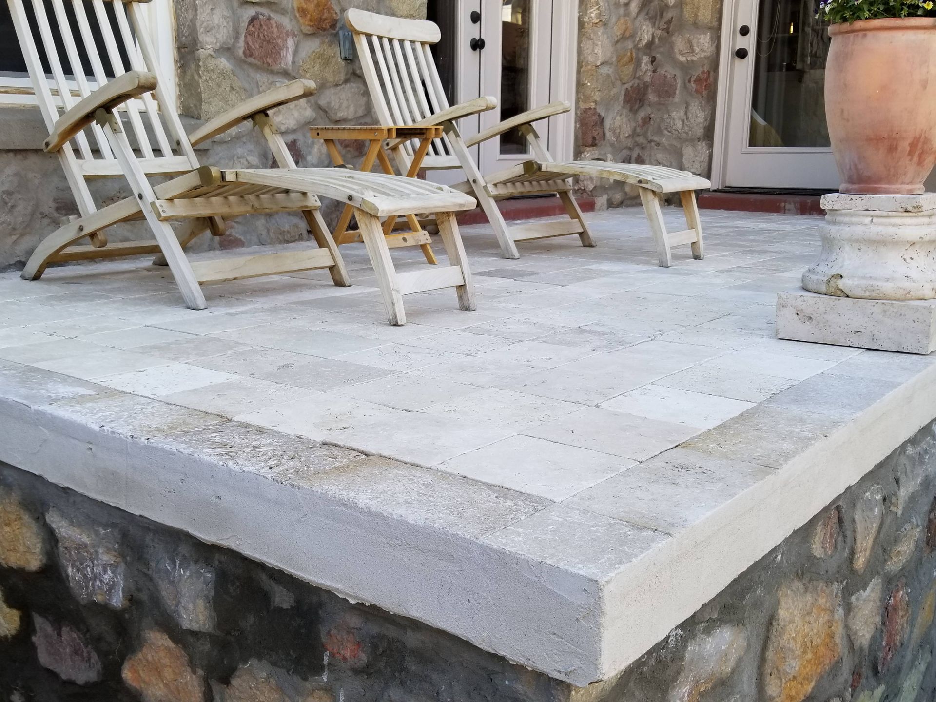 A patio with chairs and a potted plant
