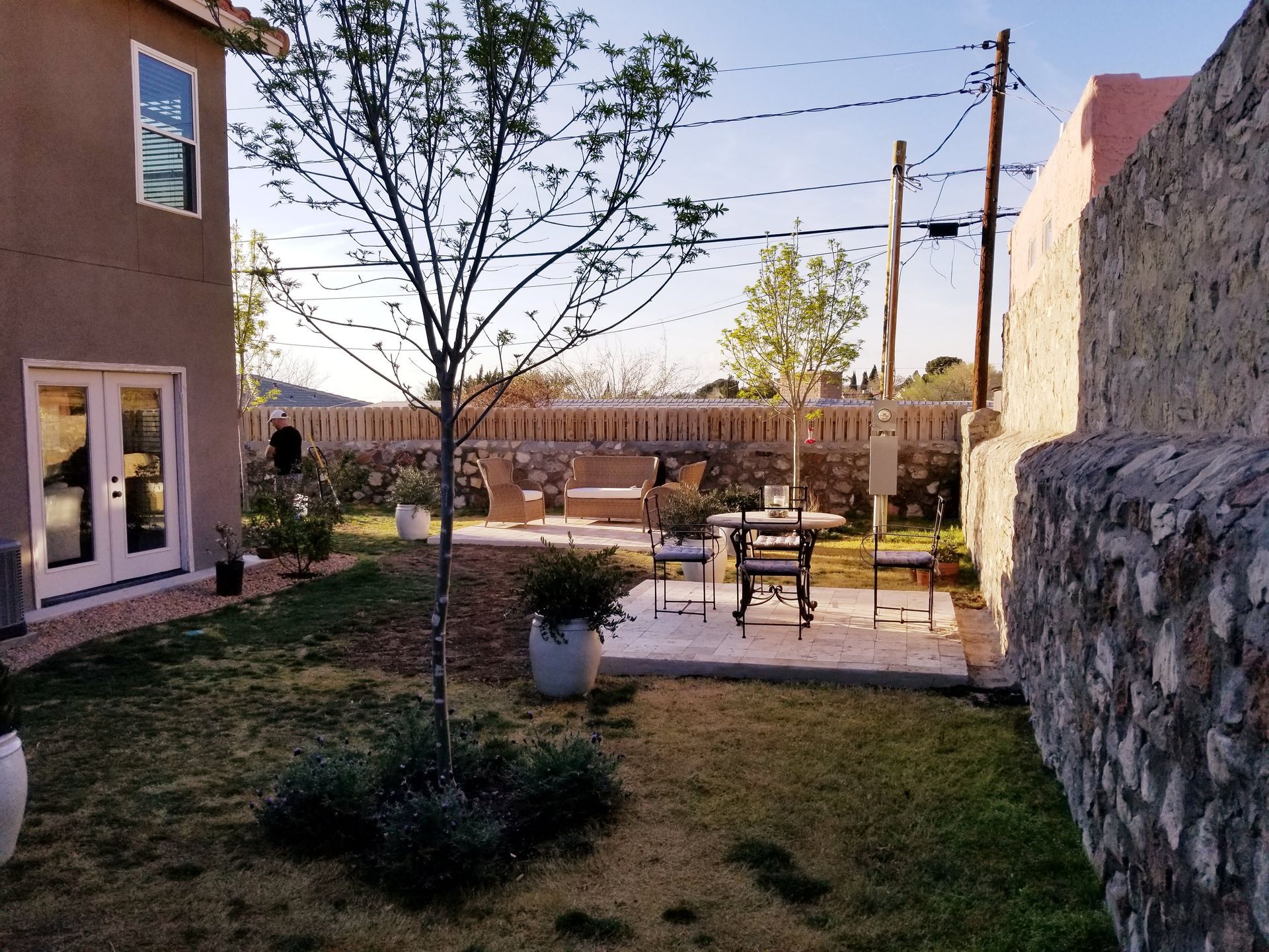 A backyard with a table and chairs and a stone wall