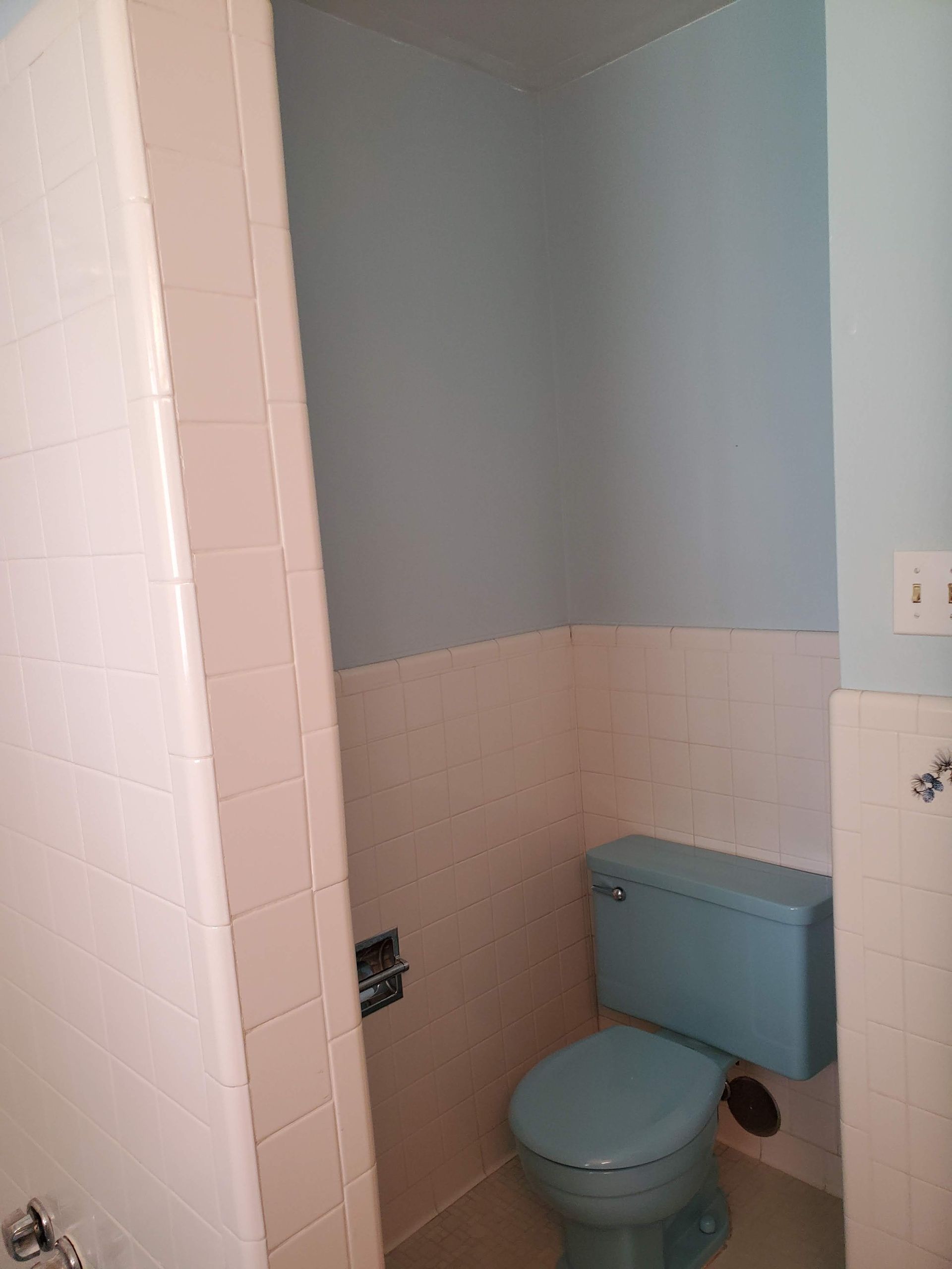 A bathroom with a blue toilet and a bathtub.