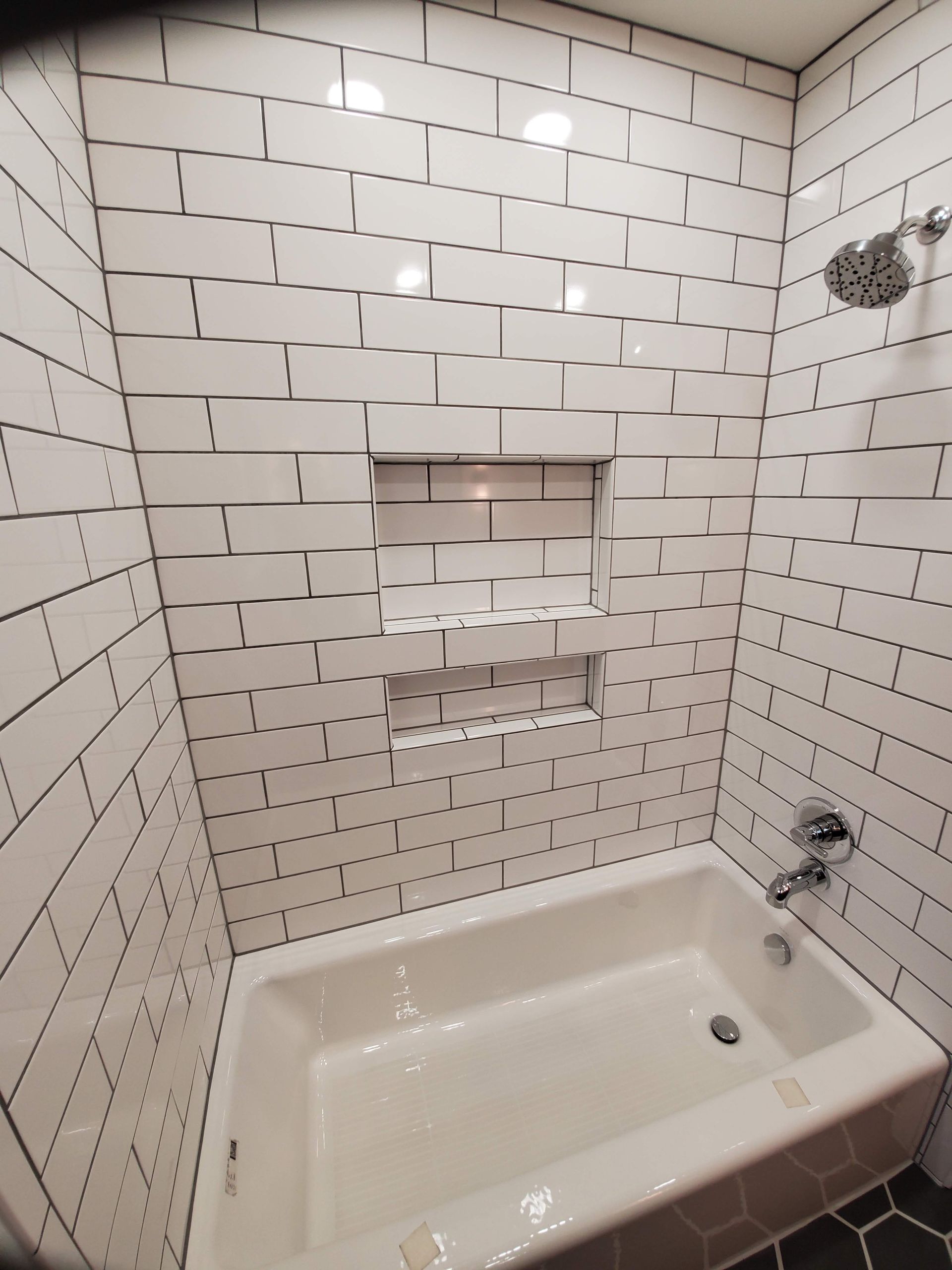A bathtub in a bathroom with white brick walls