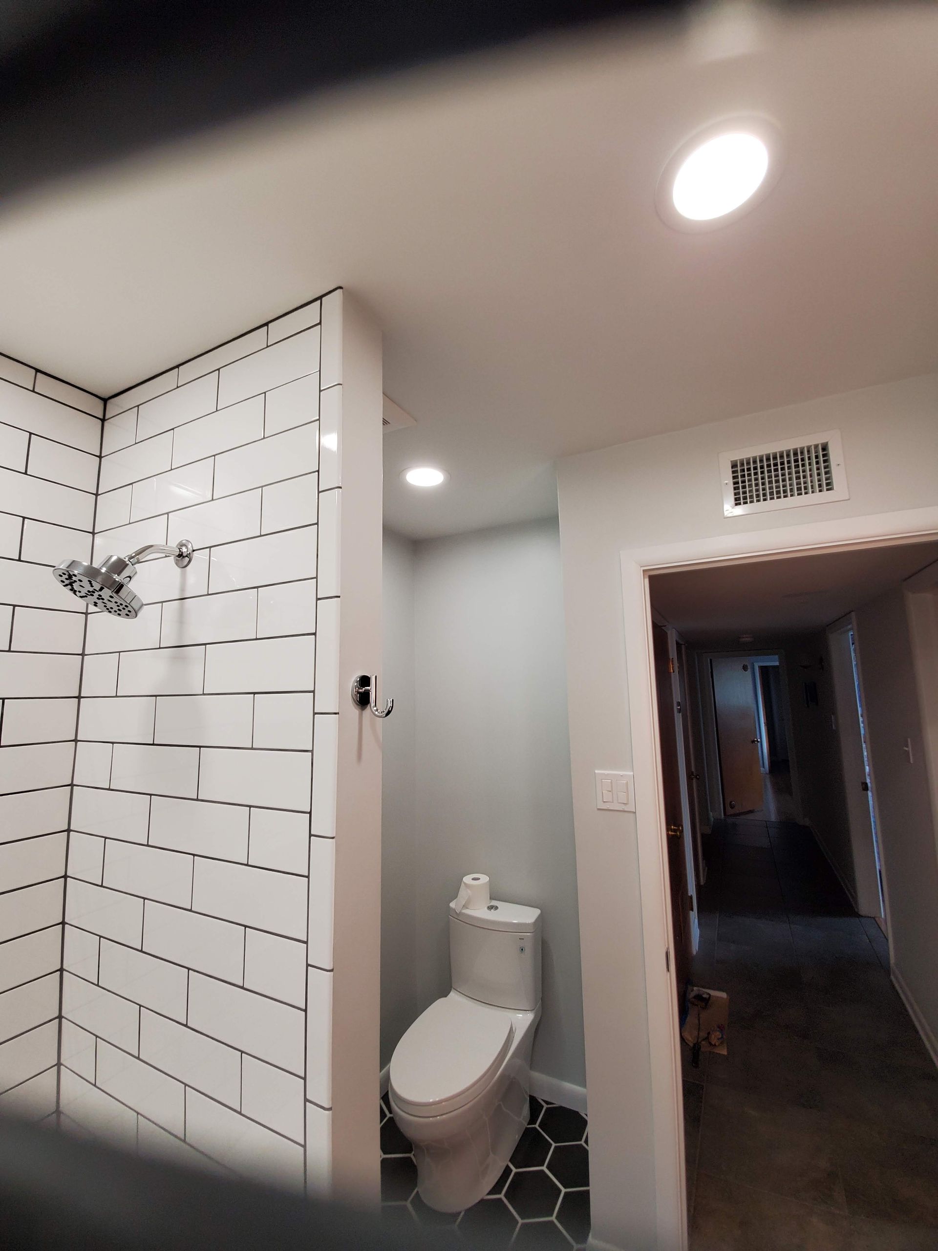 A bathroom with a toilet and a shower.