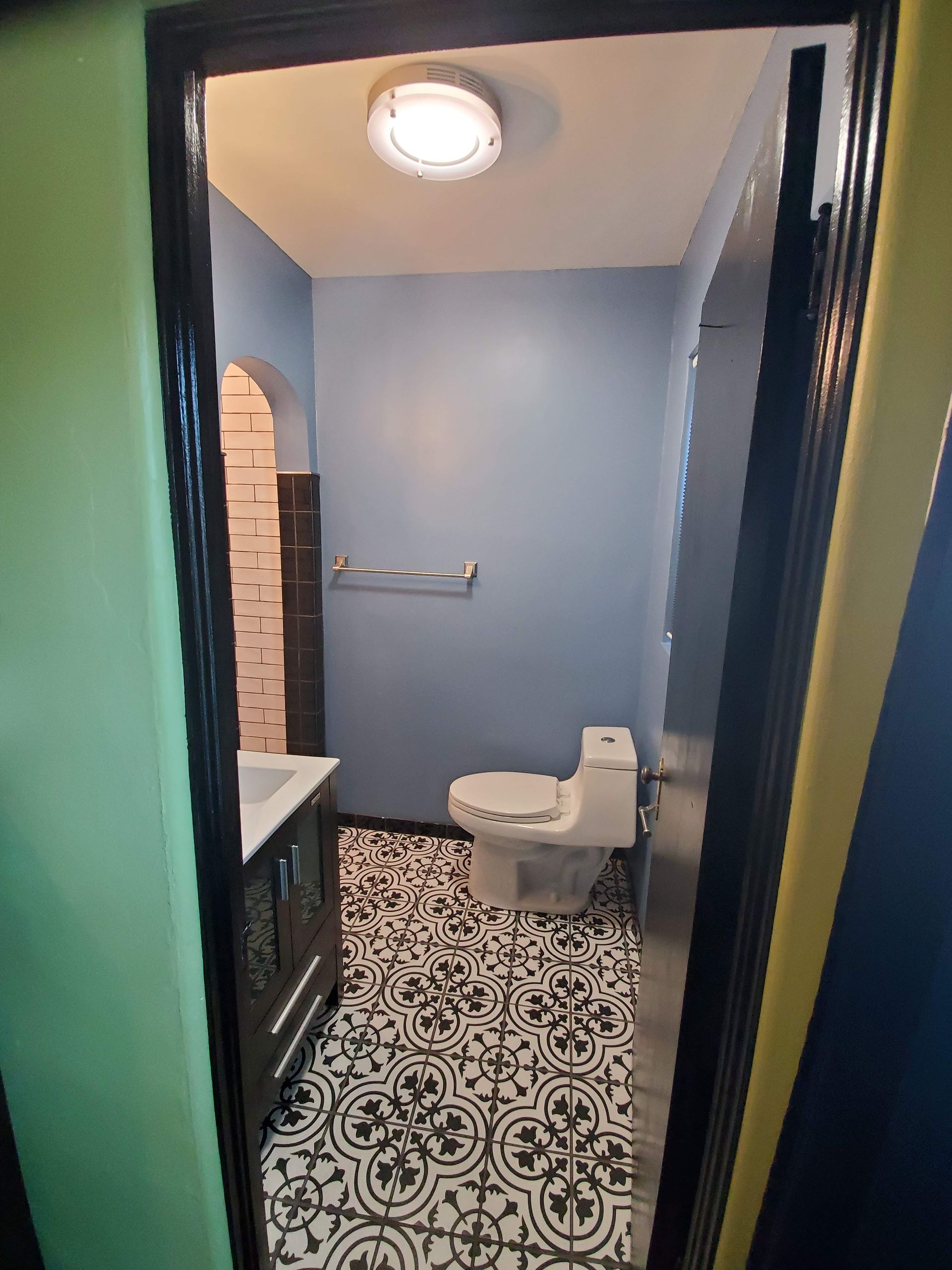 A bathroom with a toilet , sink , and blue walls.