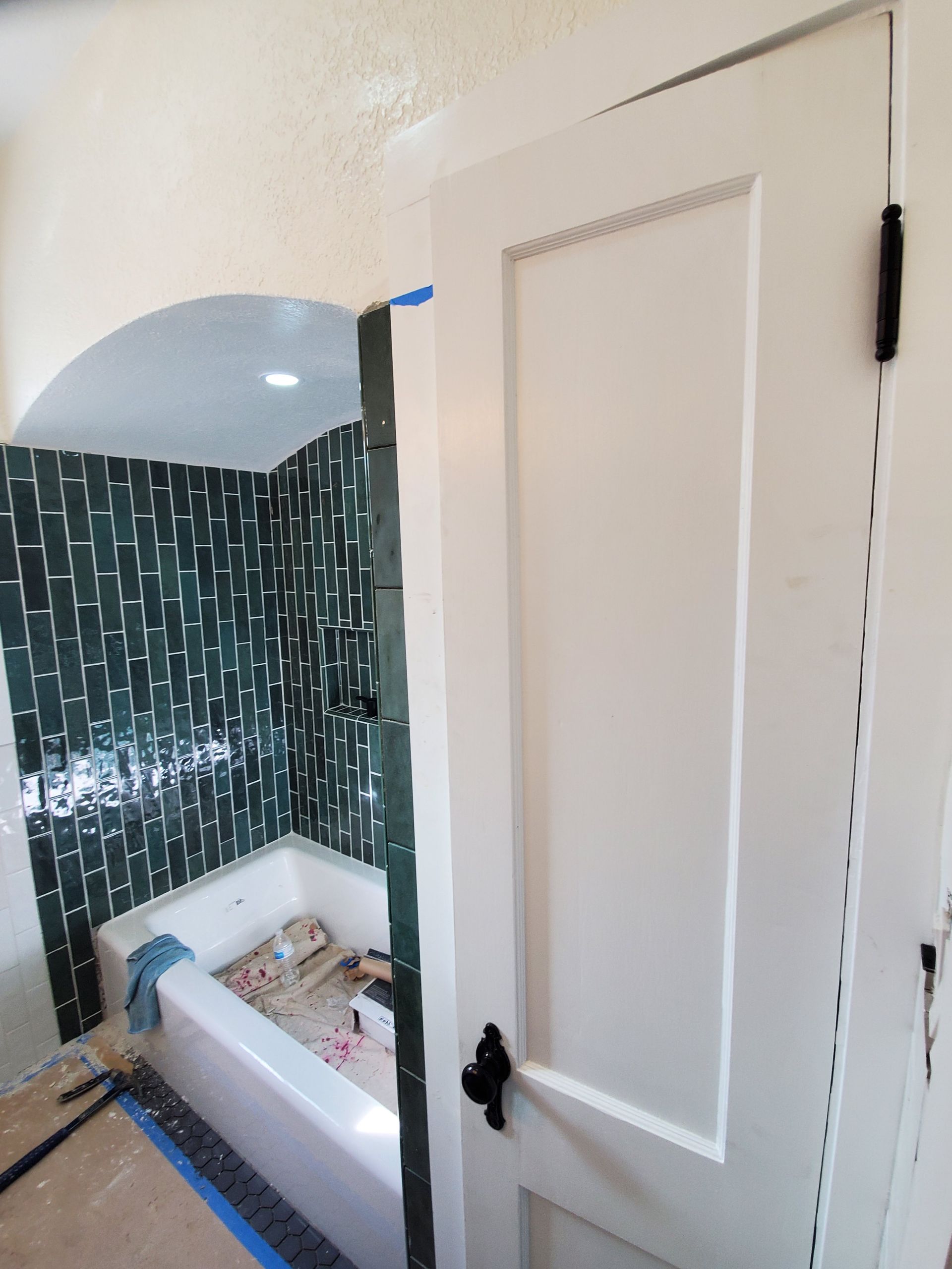 A bathroom with a bathtub and a white door