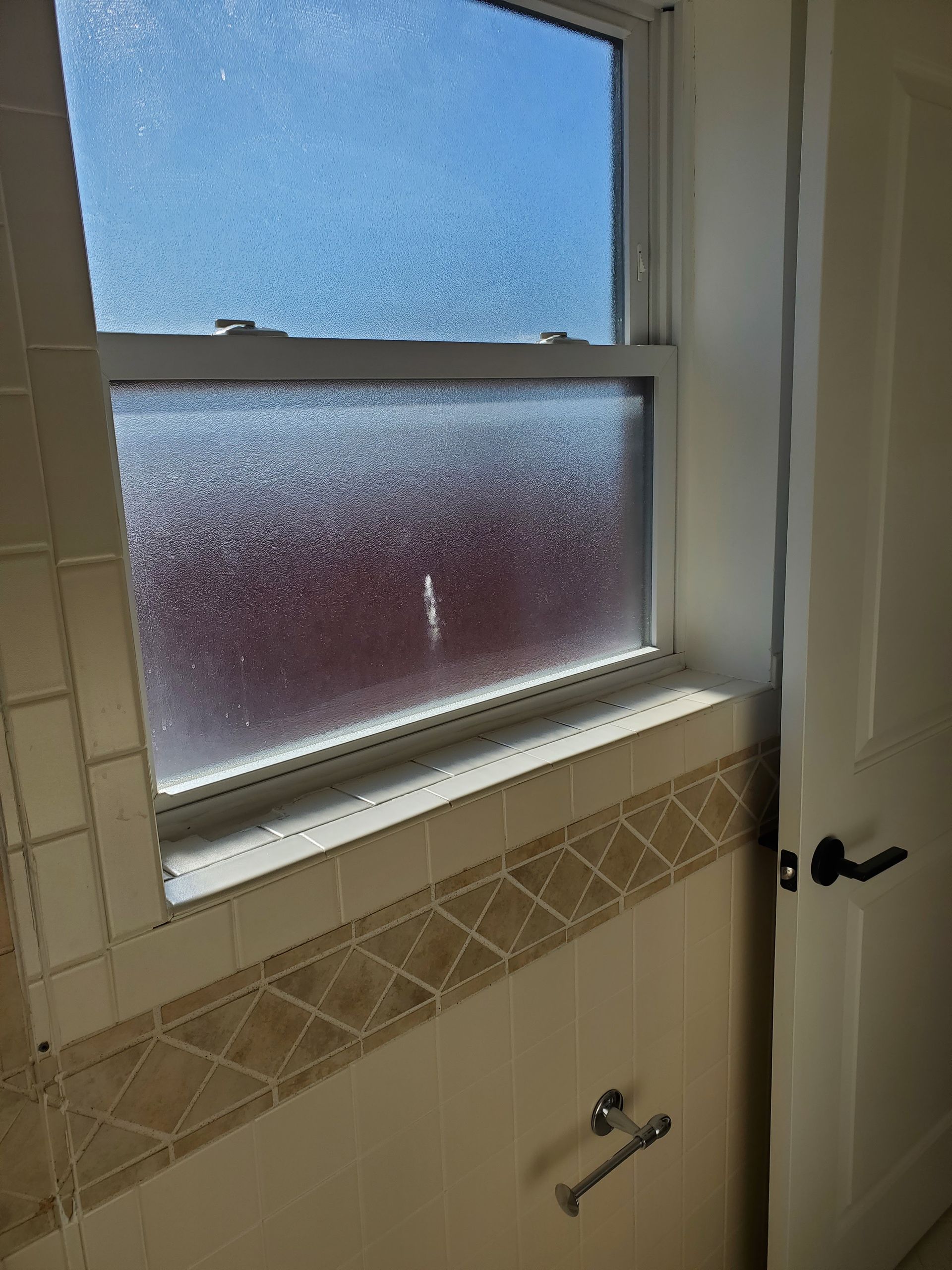 A bathroom with a window and a door.
