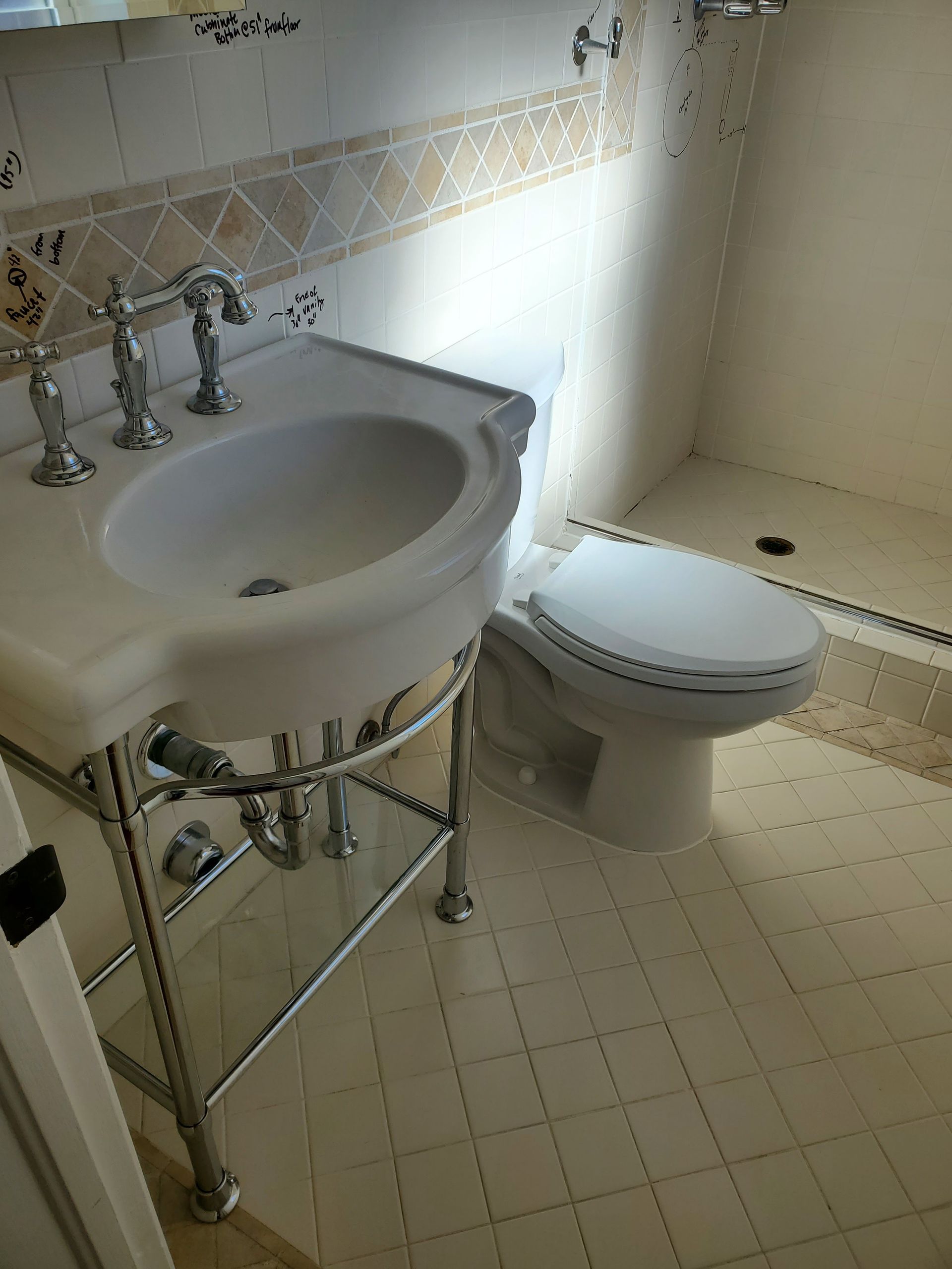 A bathroom with a sink , toilet and shower.