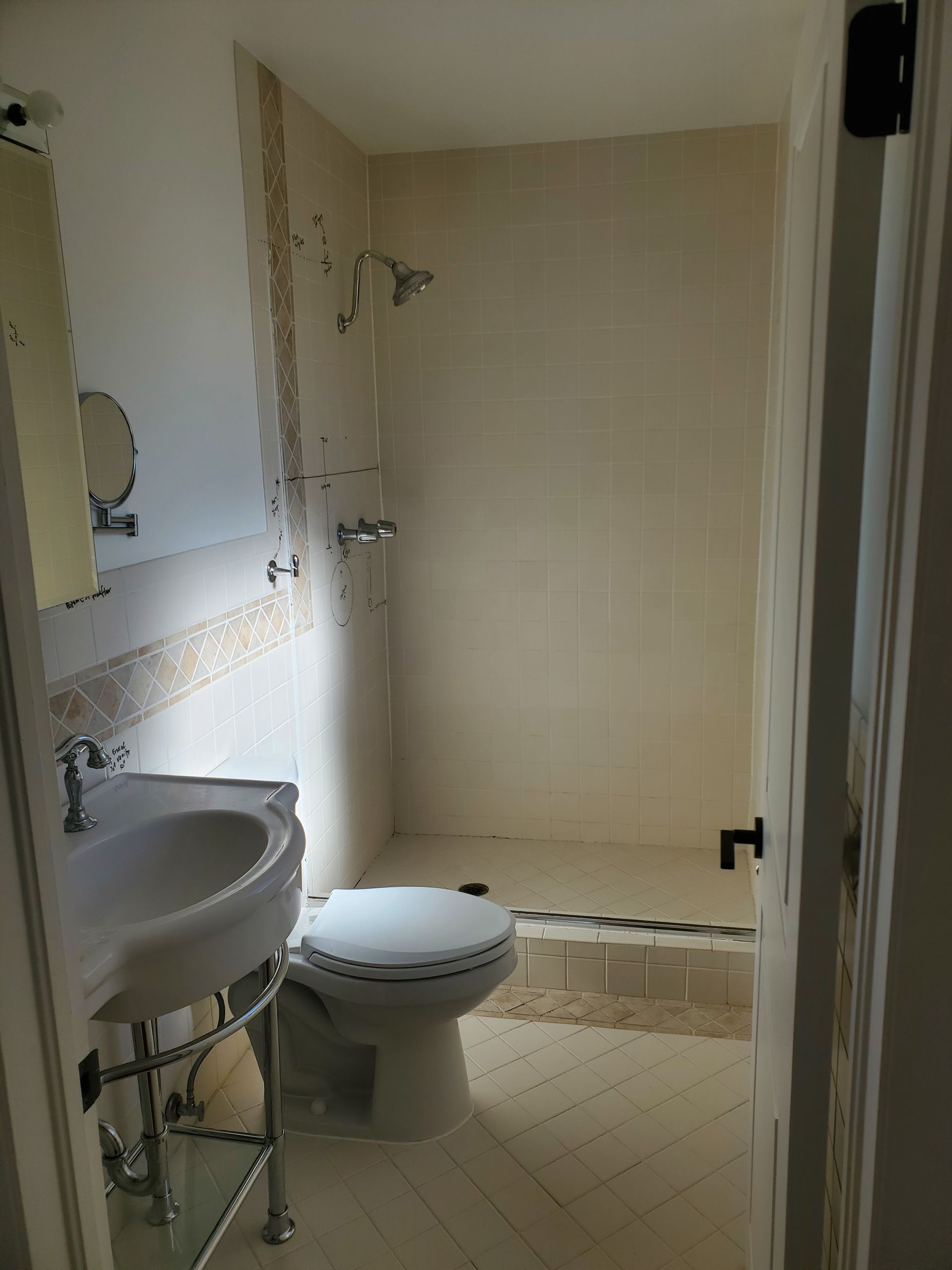 A bathroom with a toilet , sink and shower.