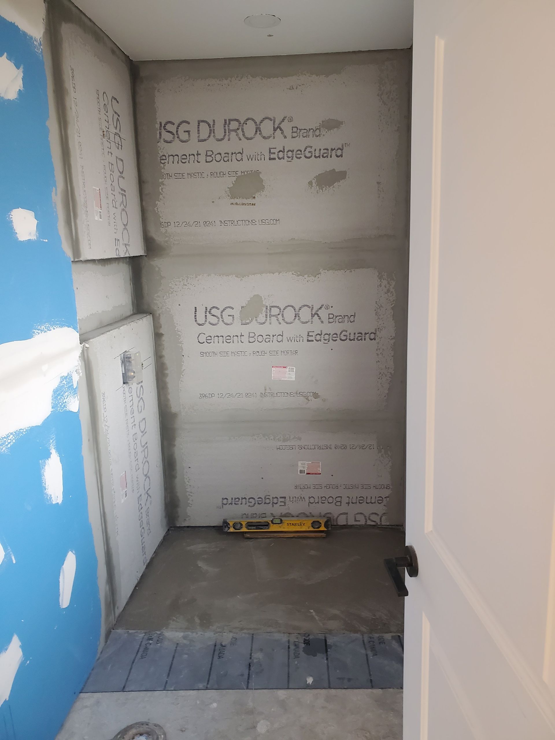 A bathroom under construction with a yellow level on the floor