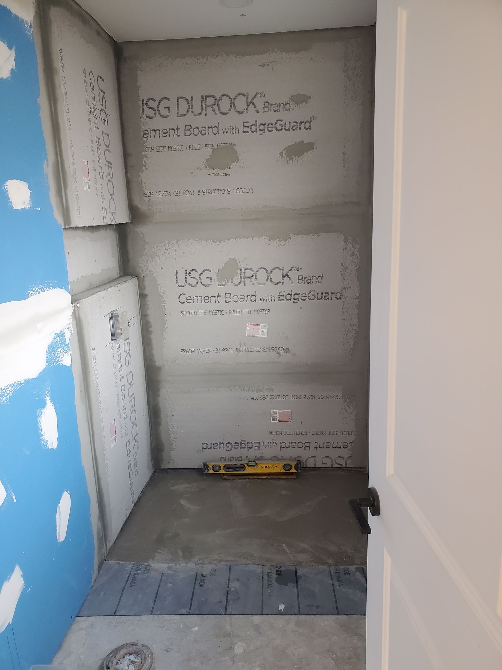 A bathroom under construction with a level on the floor.