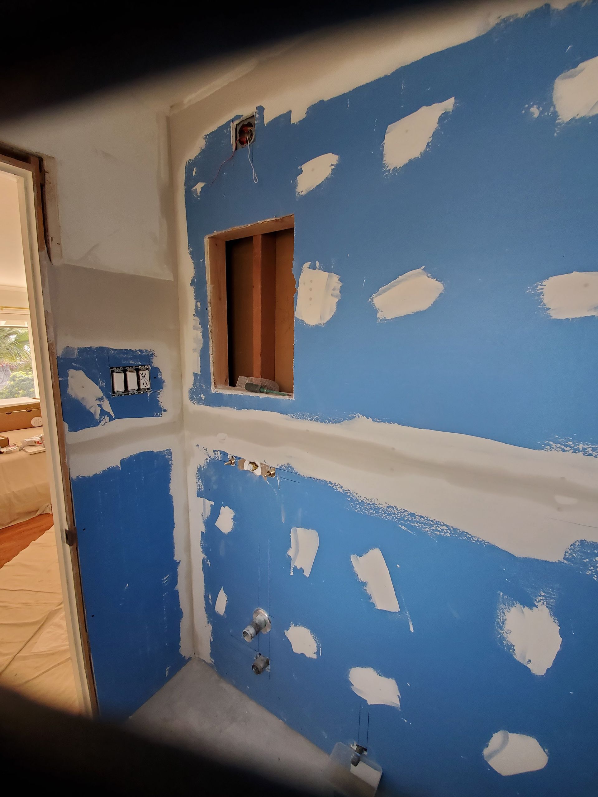 A bathroom under construction with blue walls and white trim