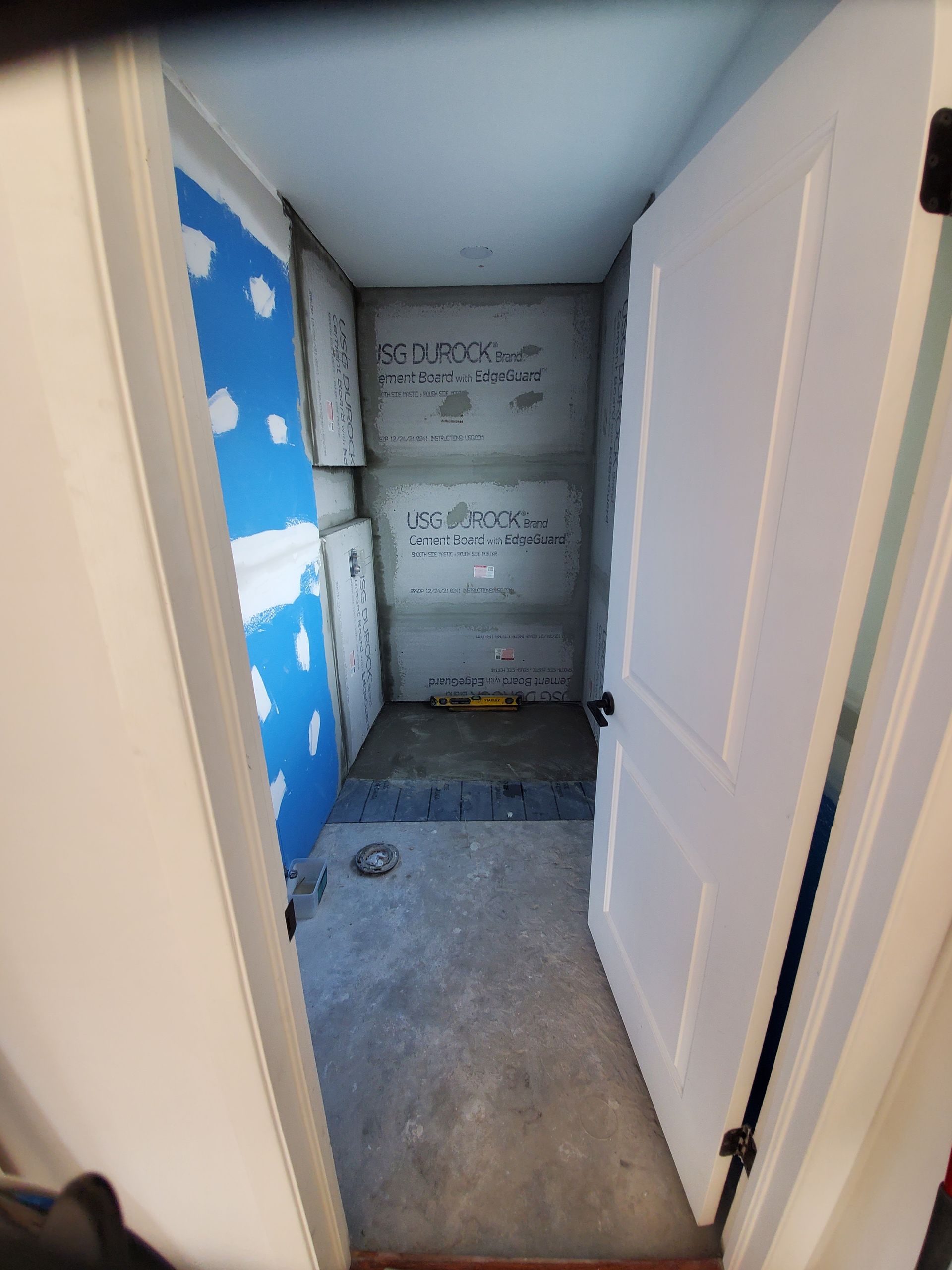 A white door is open to a small room with blue walls.