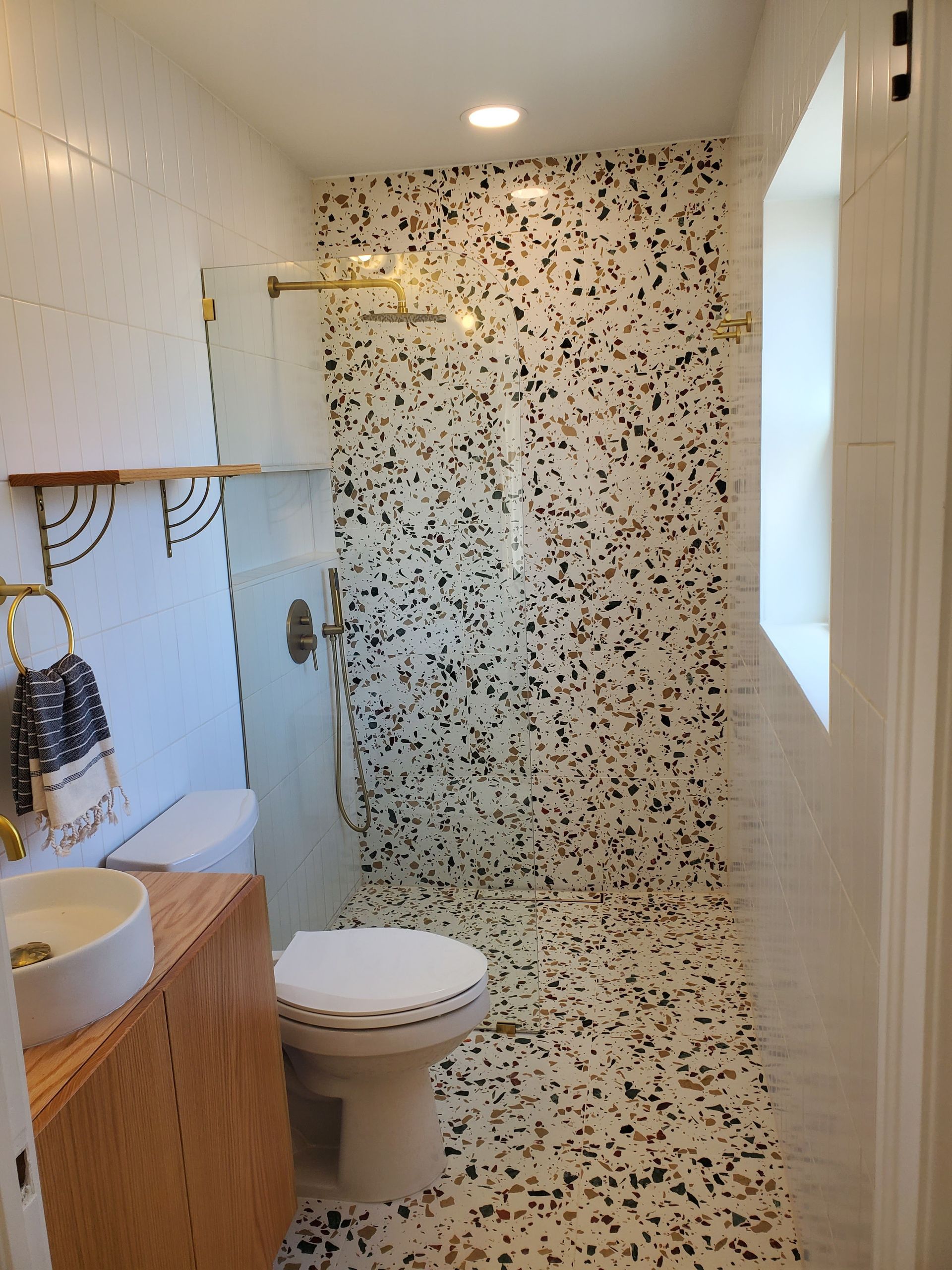 A bathroom with a toilet , sink and shower.