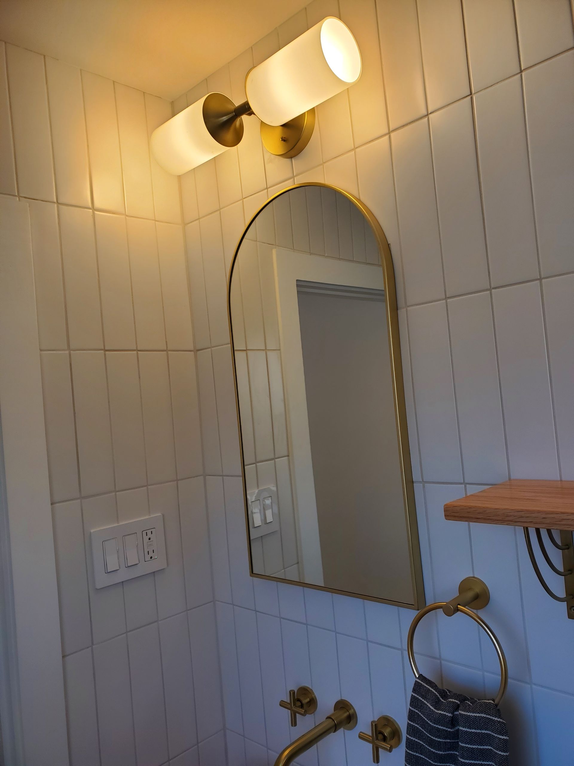 A bathroom with a large mirror and a faucet