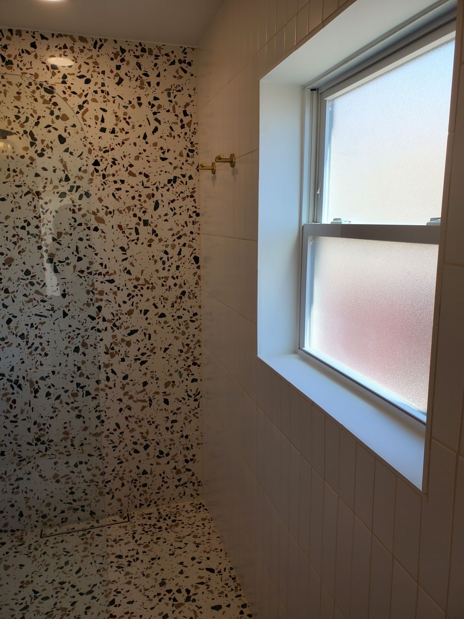A bathroom with a shower and a window