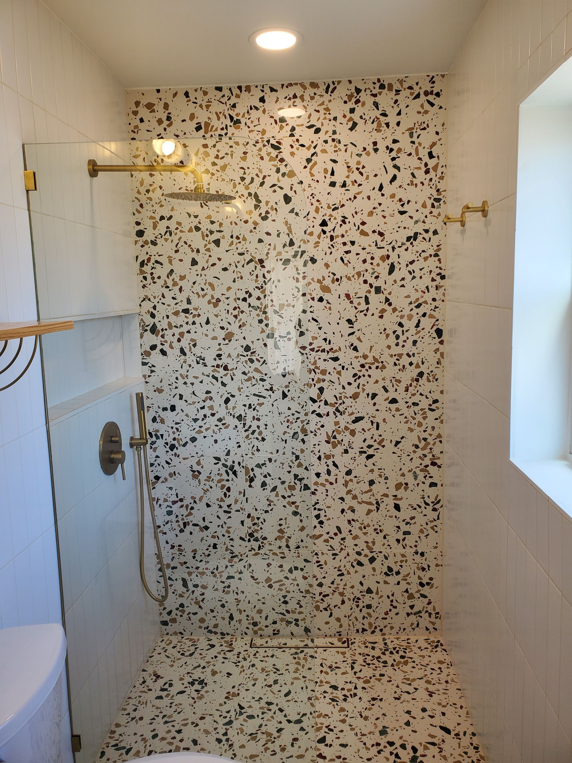 A bathroom with a walk in shower and a toilet.