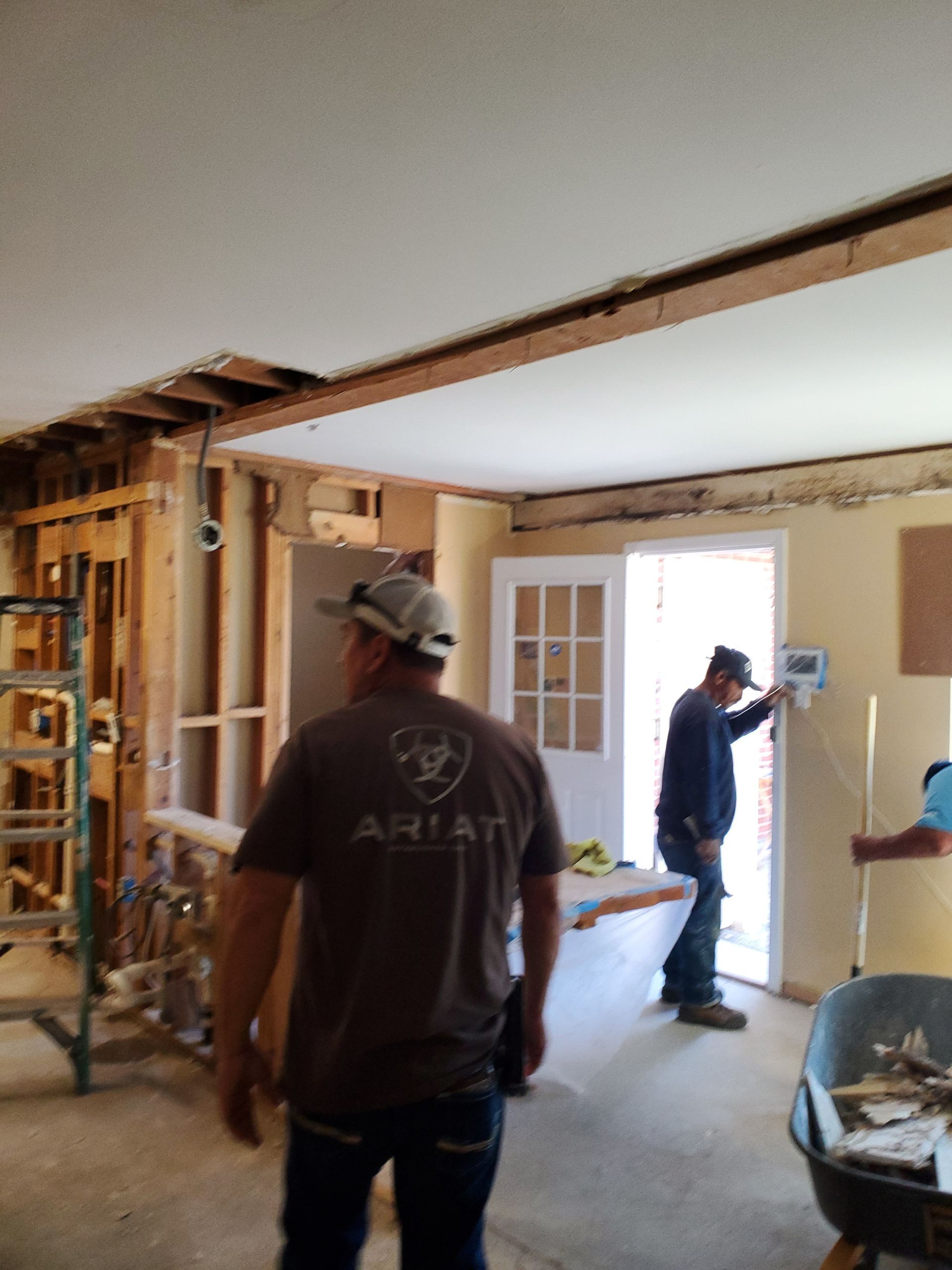 A man wearing an ariat shirt is standing in a room