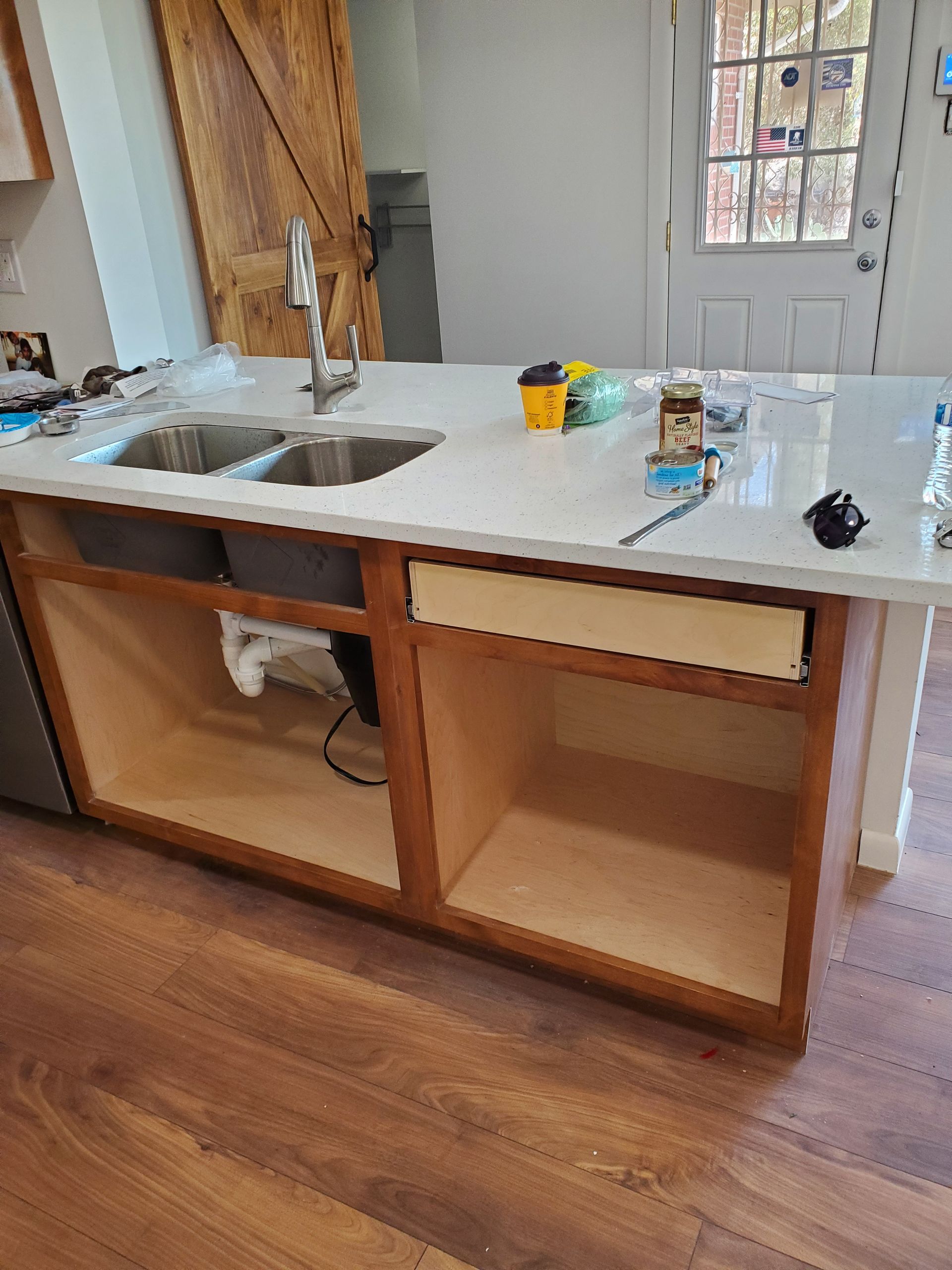 A kitchen island with two sinks and a stainless steel faucet.
