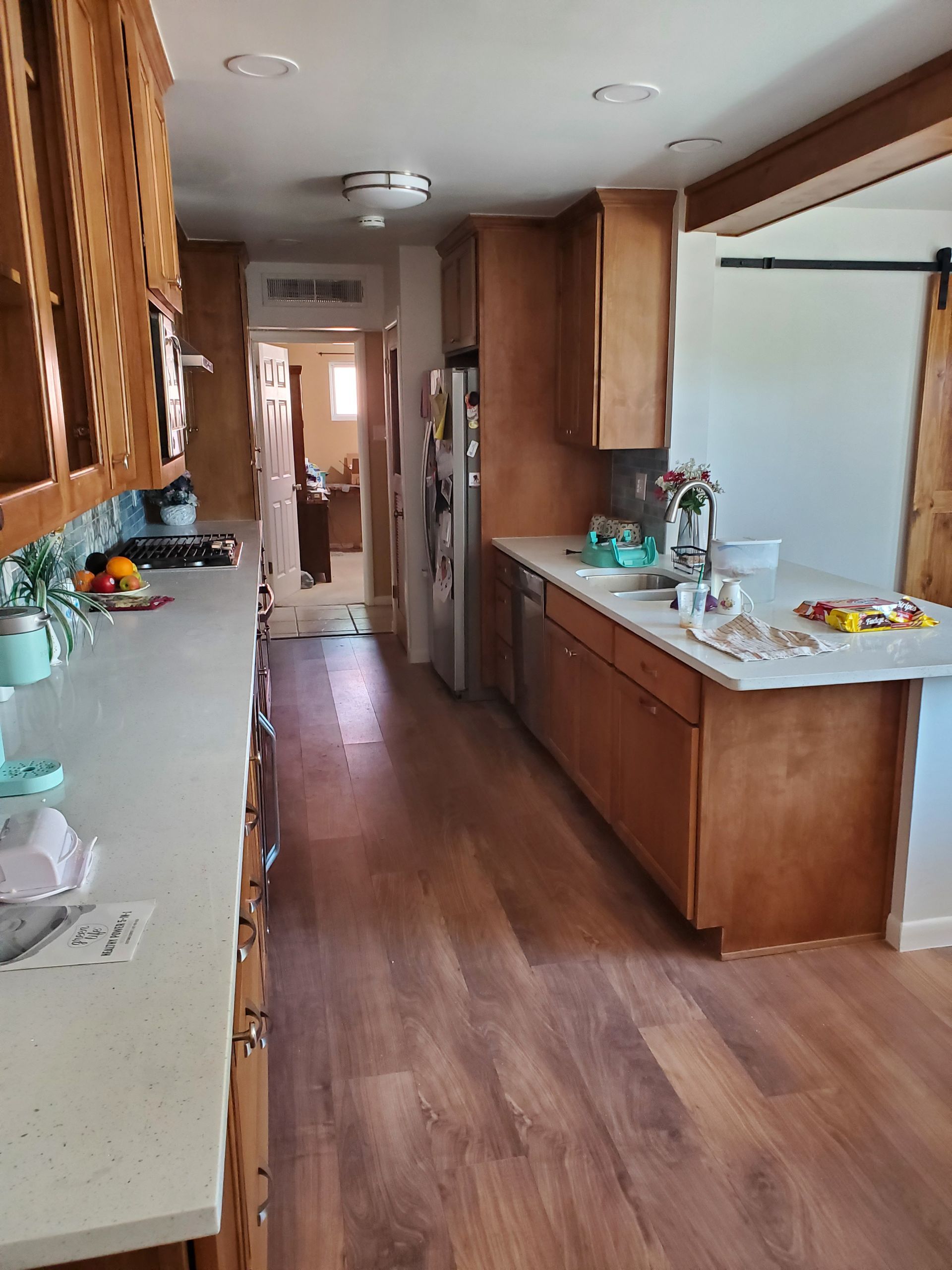 A kitchen with wooden cabinets , granite counter tops , and hardwood floors.