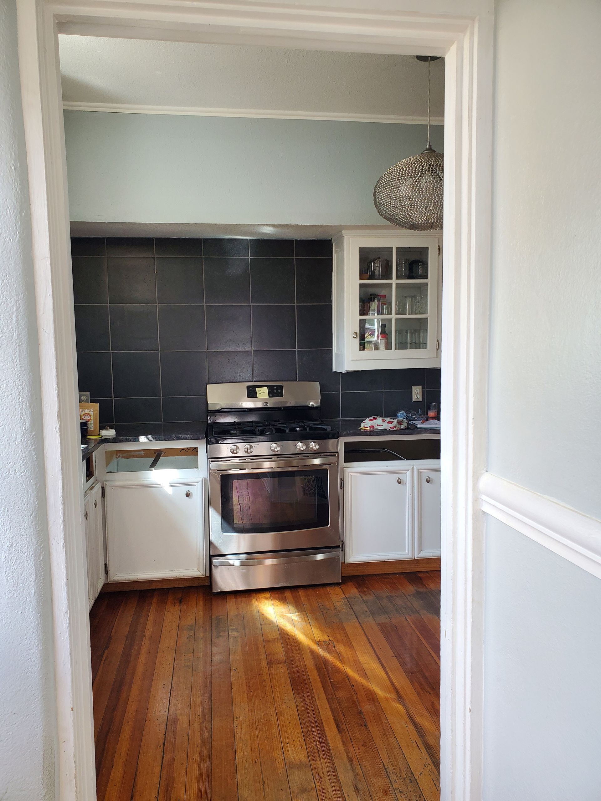 A kitchen with stainless steel appliances and wooden floors