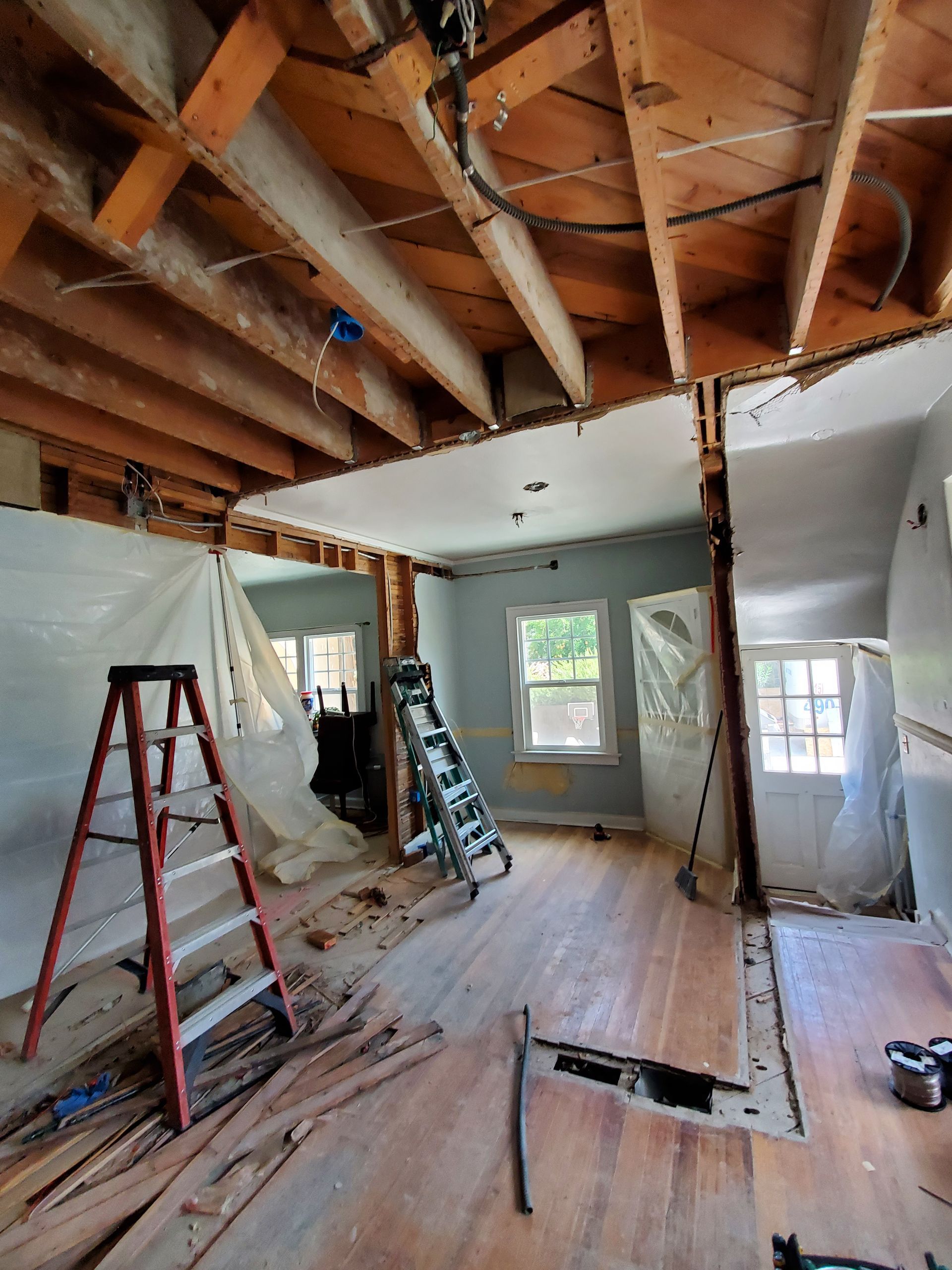 A ladder is sitting in the middle of a room under construction.